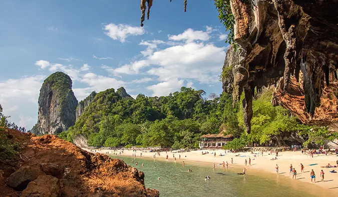 een zonnig uitzicht op het strand in Thailand, omlijst met rotspartijen