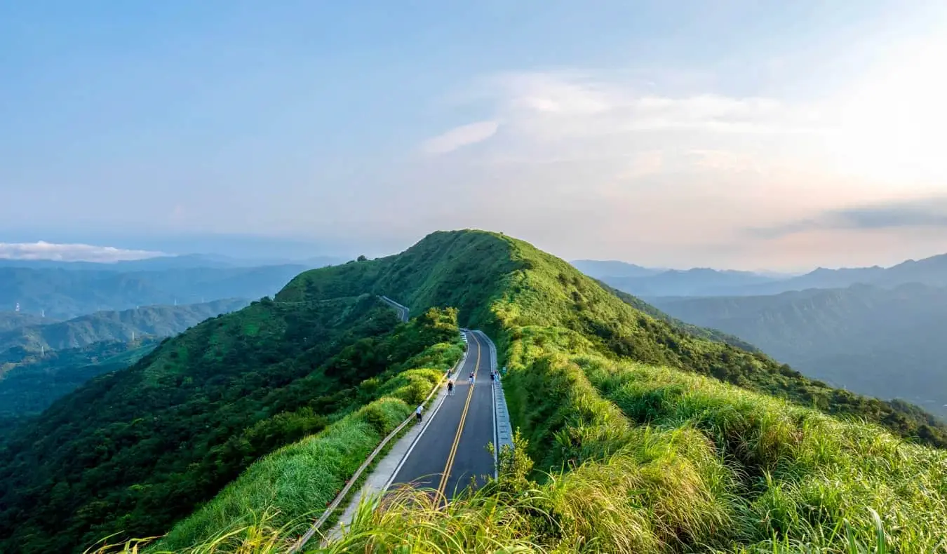 Pemandangan puncak bukit dari jalan yang menghilang di sekitar puncak gunung