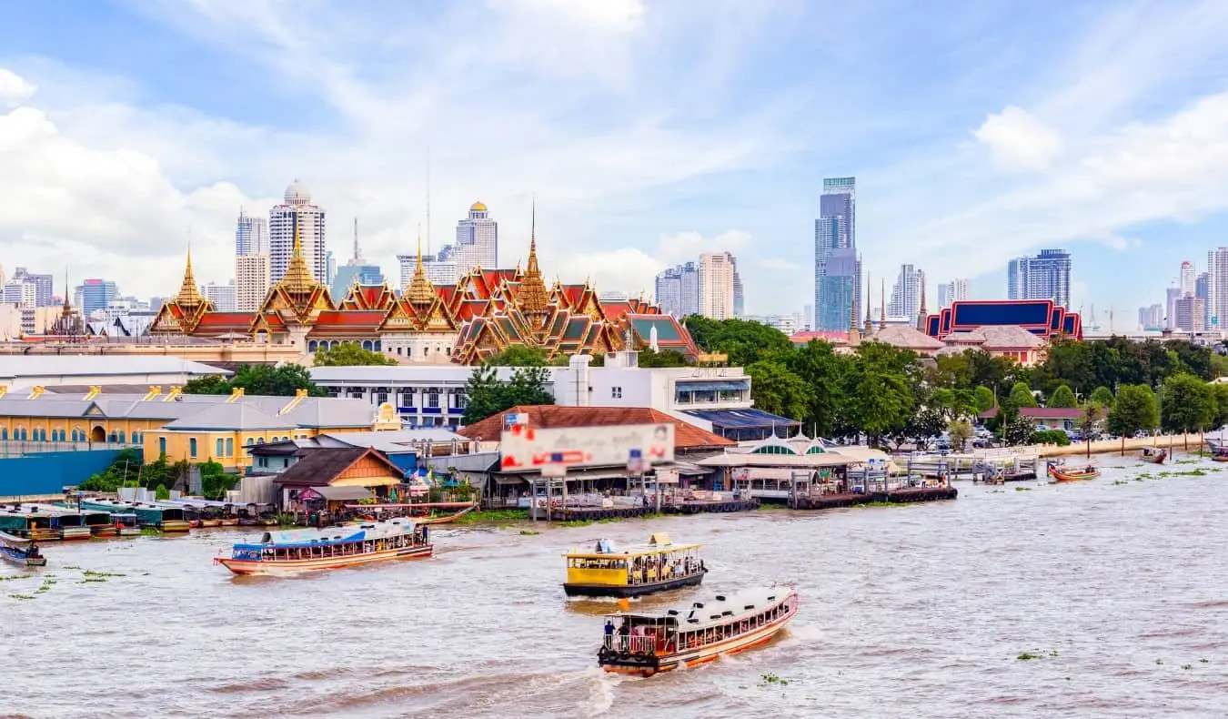 Nehirde yüzen teknelerle Bangkok, Tayland'ın silueti