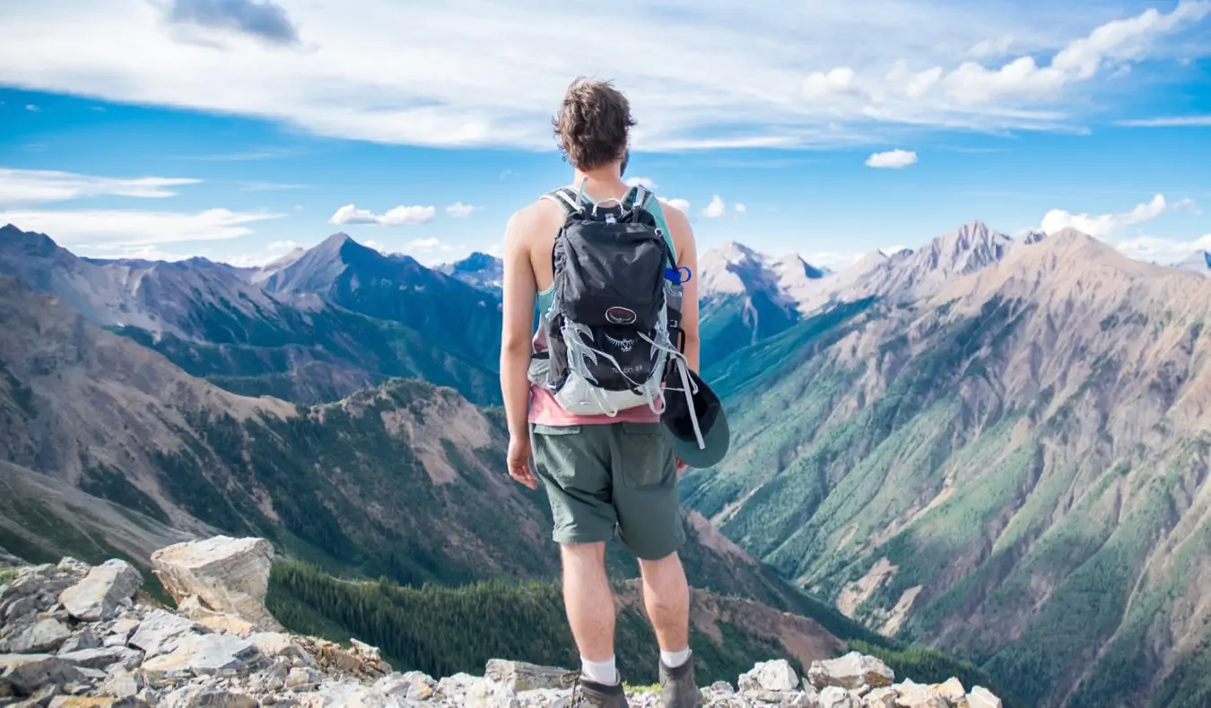 En solo backpacker stående på en klippe og ser på landskabet