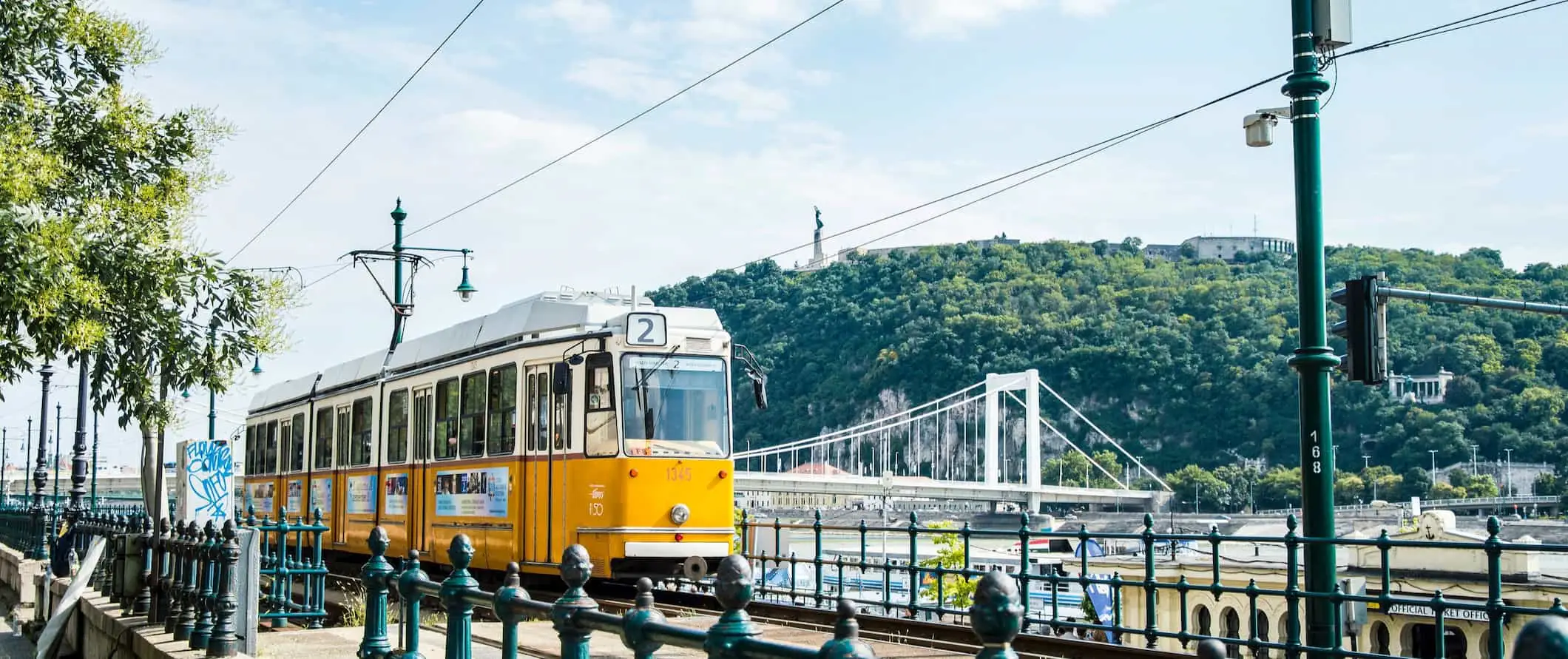 Trem kuning bergolek di sepanjang hari yang cerah di Budapest, Hungary