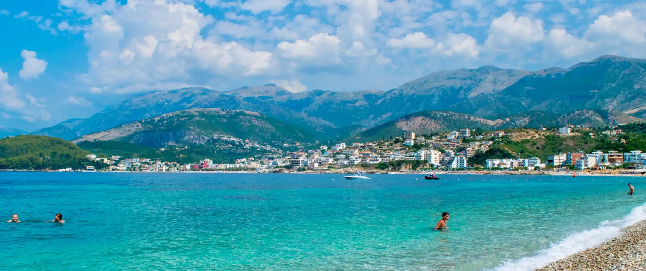 Et gammelt steintårn og steinmur i Albania med bølgende åser og fjell i det fjerne