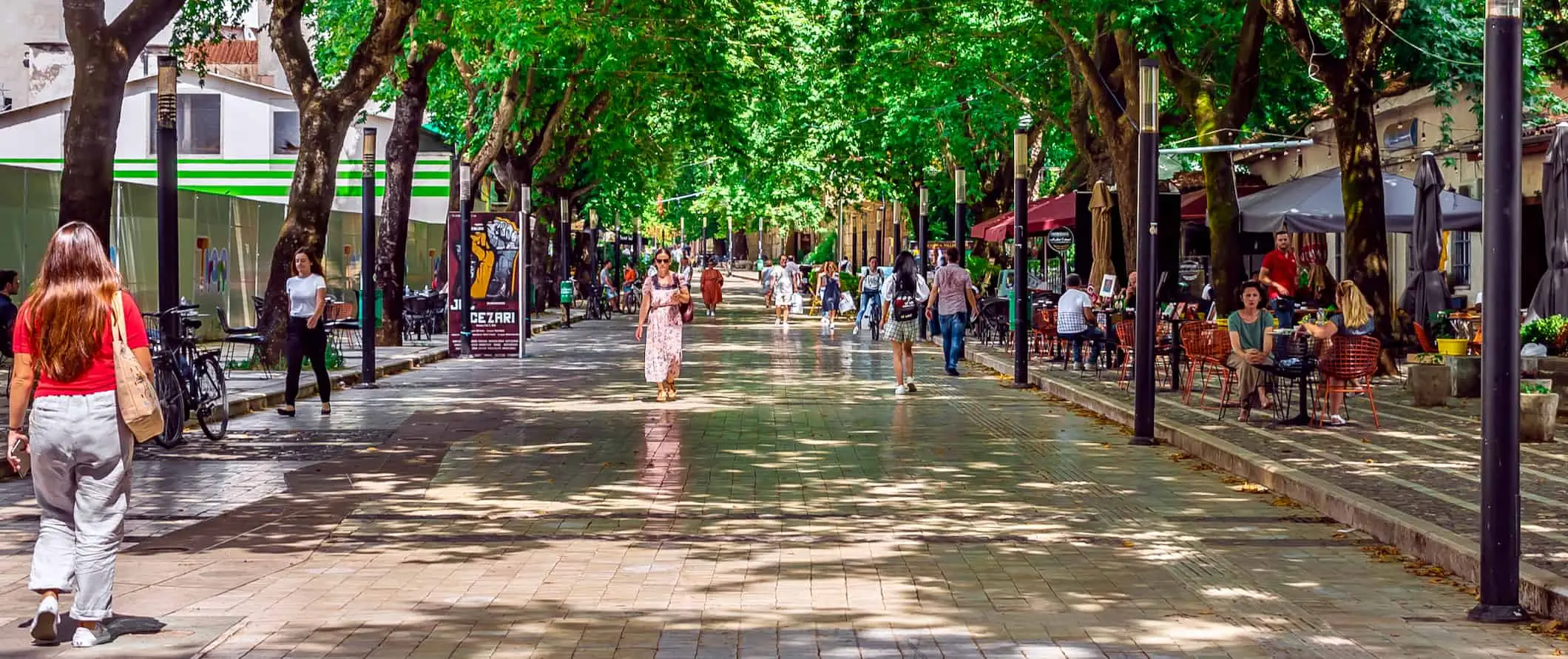 Arnavutluk'ta eski bir taş kule ve taş duvar, uzakta tepeler ve dağlar var