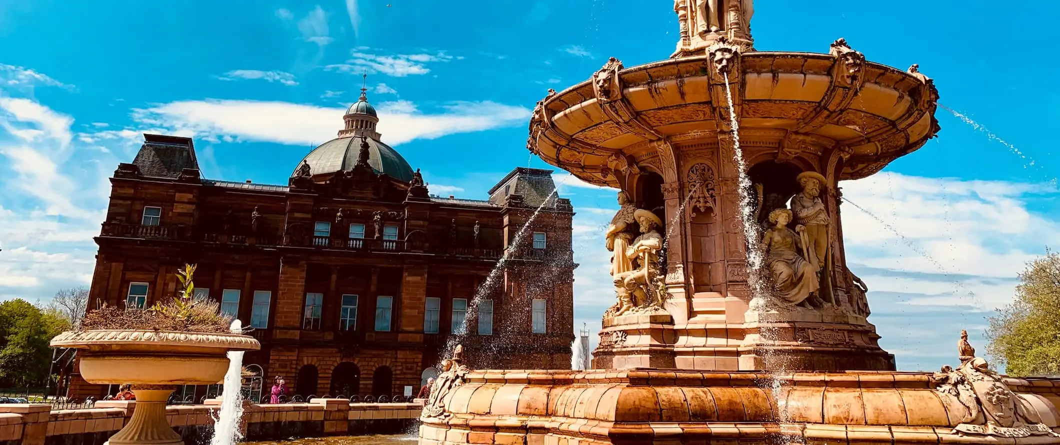 Historiske bygninger og en gammel fontene i Glasgow, Skottland på en solrik sommerdag