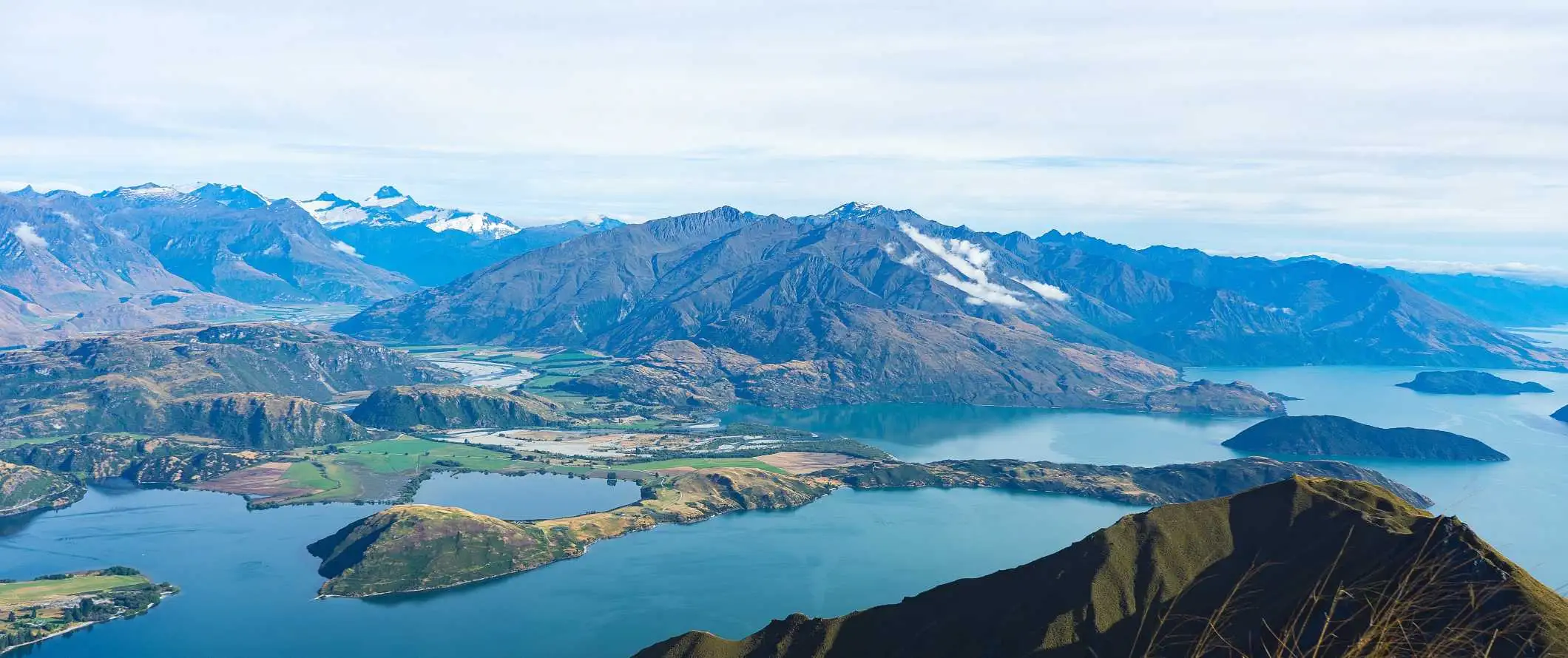 Roys Peak, znamenita gora v ospredju, z gorami in jezeri za njo v Wanaki na Novi Zelandiji