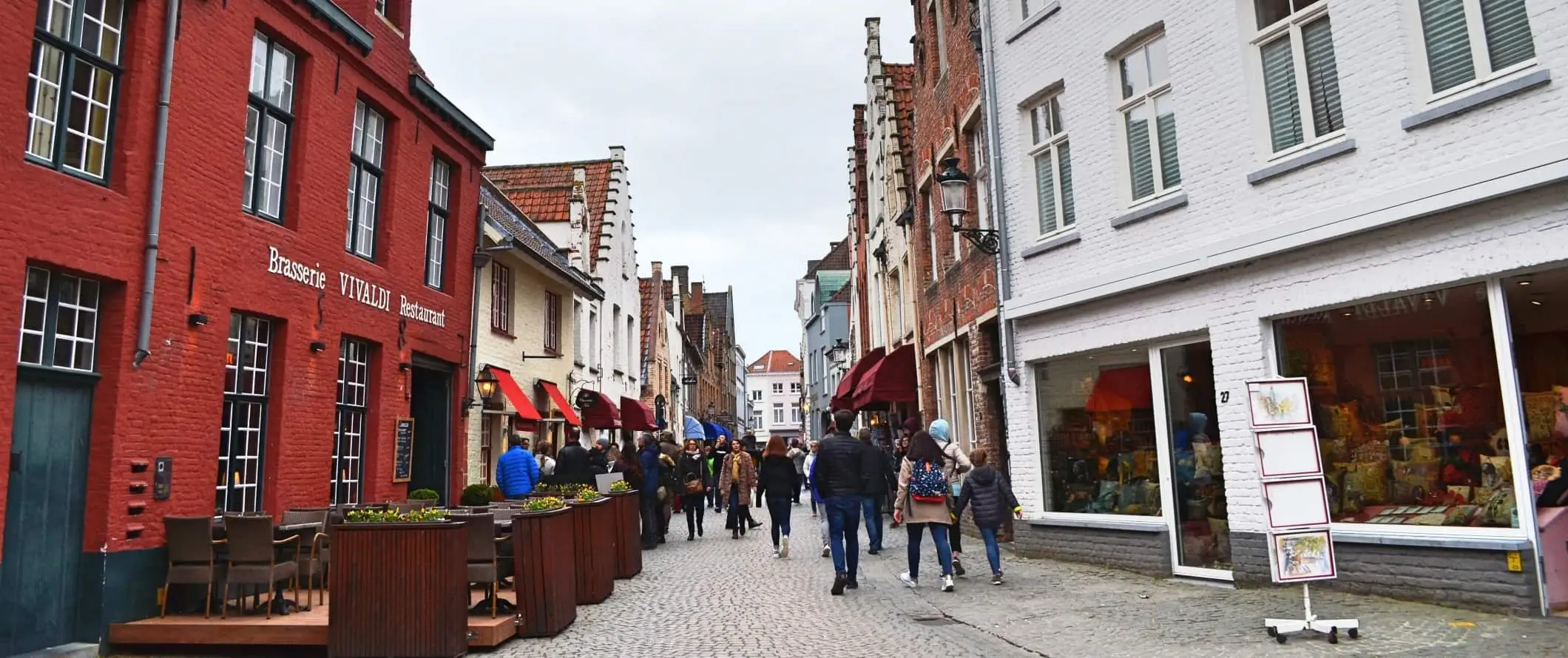 Briugėje, Belgijoje, akmenimis grįsta gatvė, kuria vaikšto žmonės.