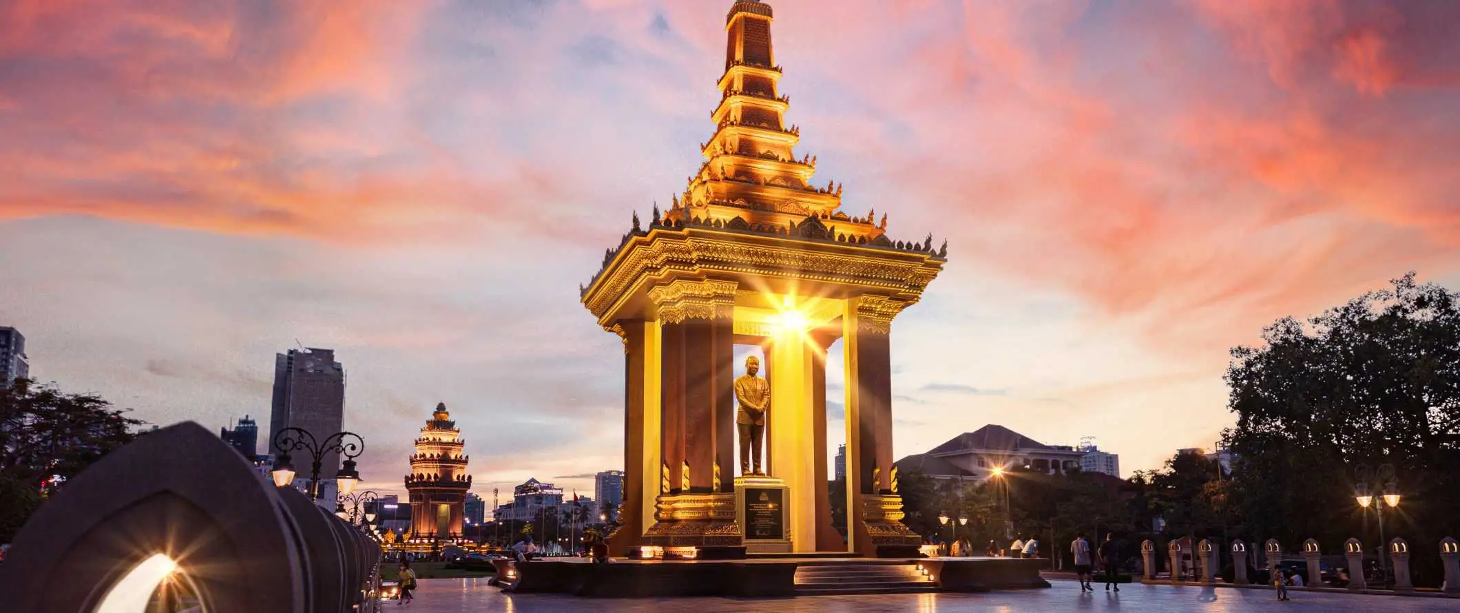 Het gouden standbeeld van wijlen koning pater Norodom Sihanouk, een belangrijk oriëntatiepunt in Phnom Penh, Cambodja bij zonsondergang