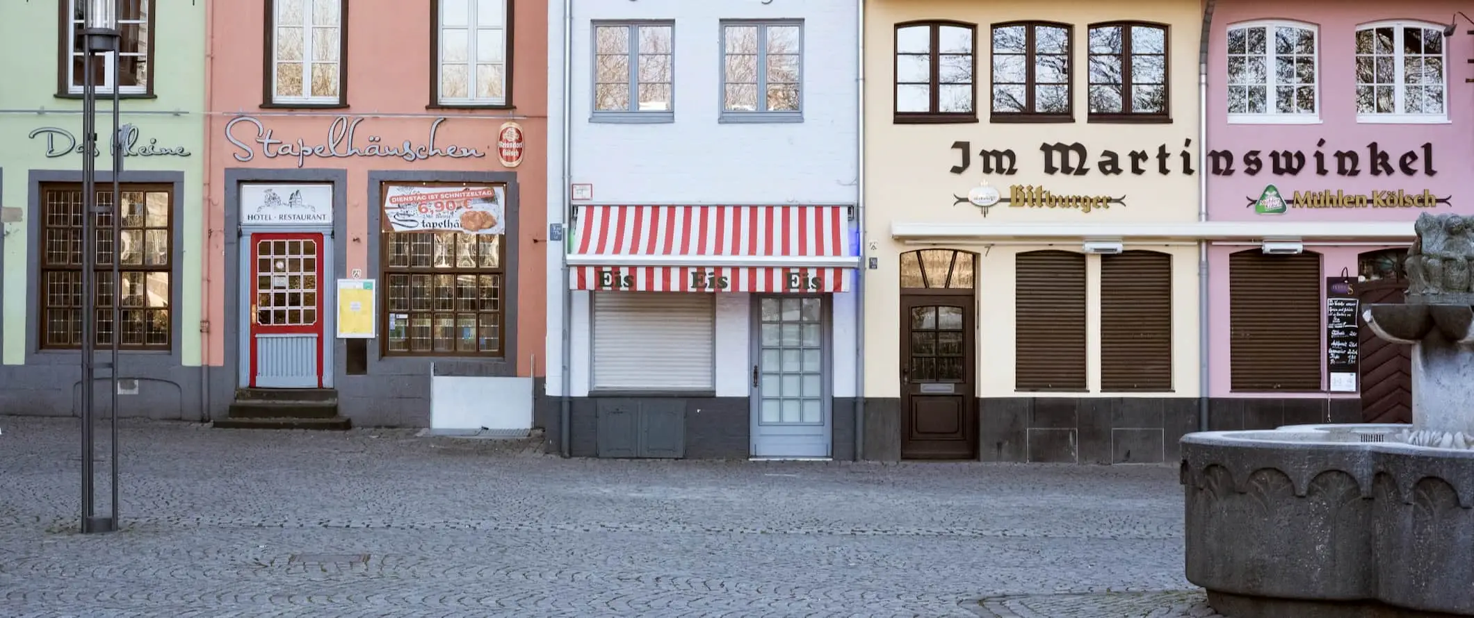 Una fila di vecchi edifici che fiancheggiano una strada a Colonia, in Germania