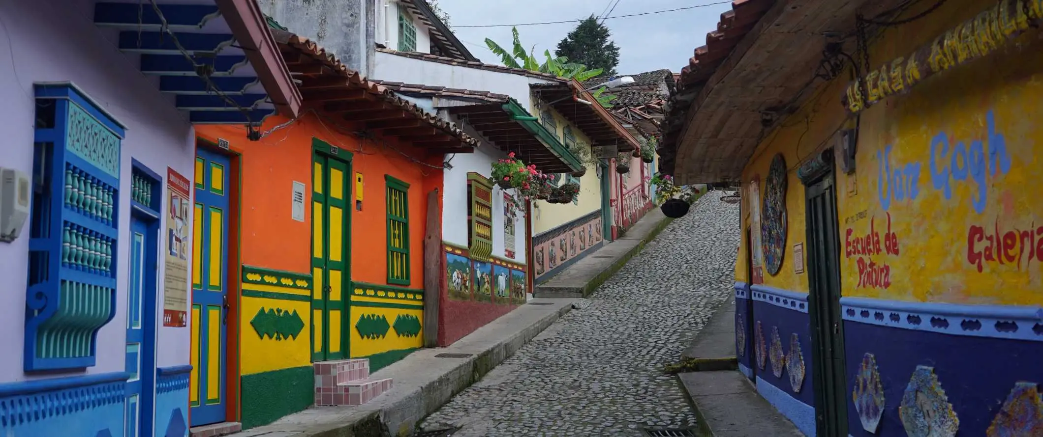 Jalan berbatu berbatu dipenuhi dengan rumah-rumah yang cerah dan bersejarah di bandar Guatapé berhampiran Medellin, Colombia