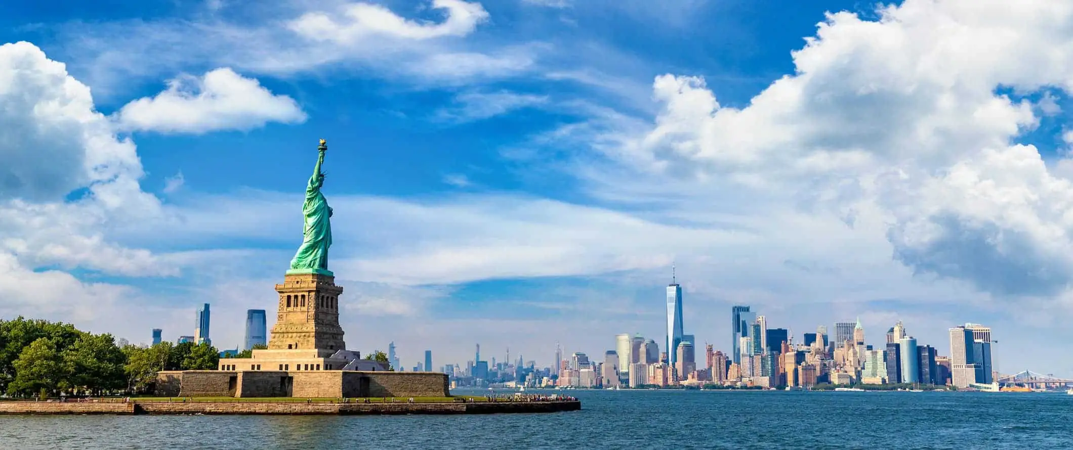 Frihetsgudinnen og NYCs skyline sett fra vannet i New York