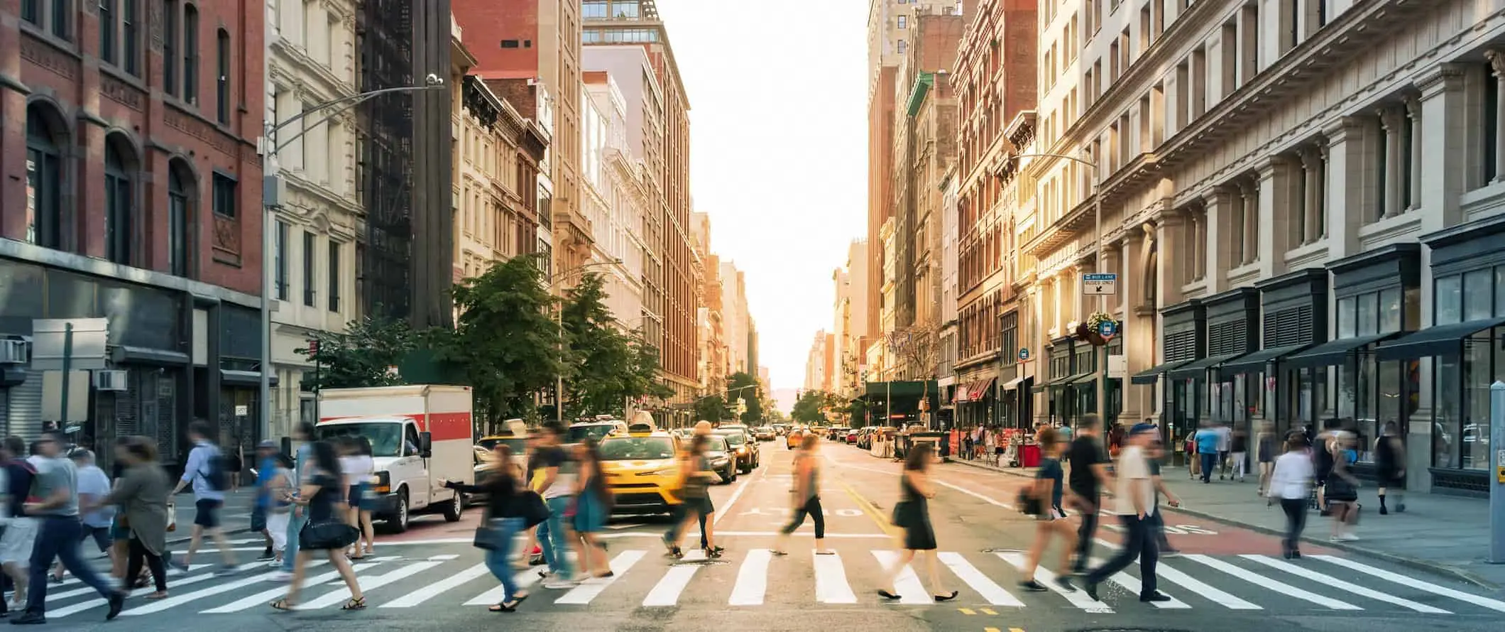 Oameni care traversează strada pe un drum aglomerat din Manhattan, NYC, SUA