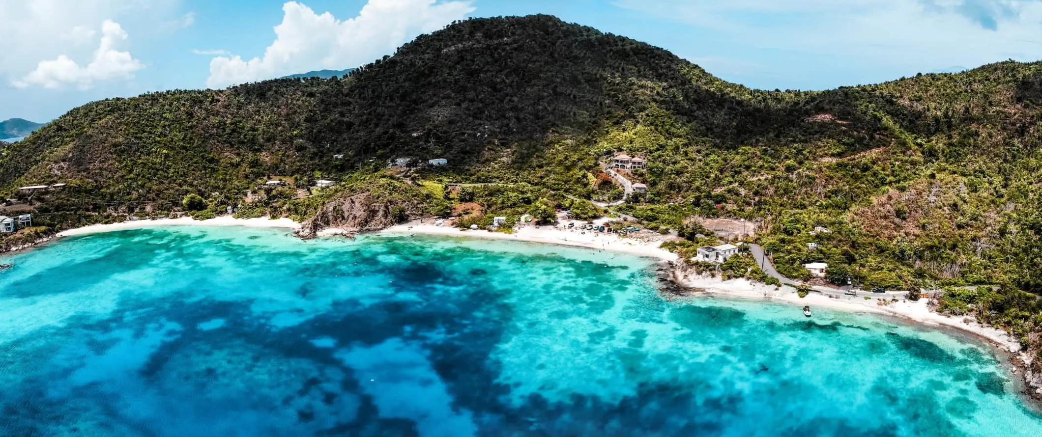 Panorámás kilátás a kristálytiszta türkizkék vízre, a fehér homokos strandokra és Saint John, USVI dombjaira