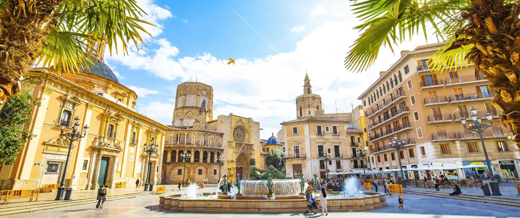 Eine entspannte Straßenszene im sonnigen Valencia, Spanien, mit historischen Gebäuden und Einheimischen, die spazieren gehen