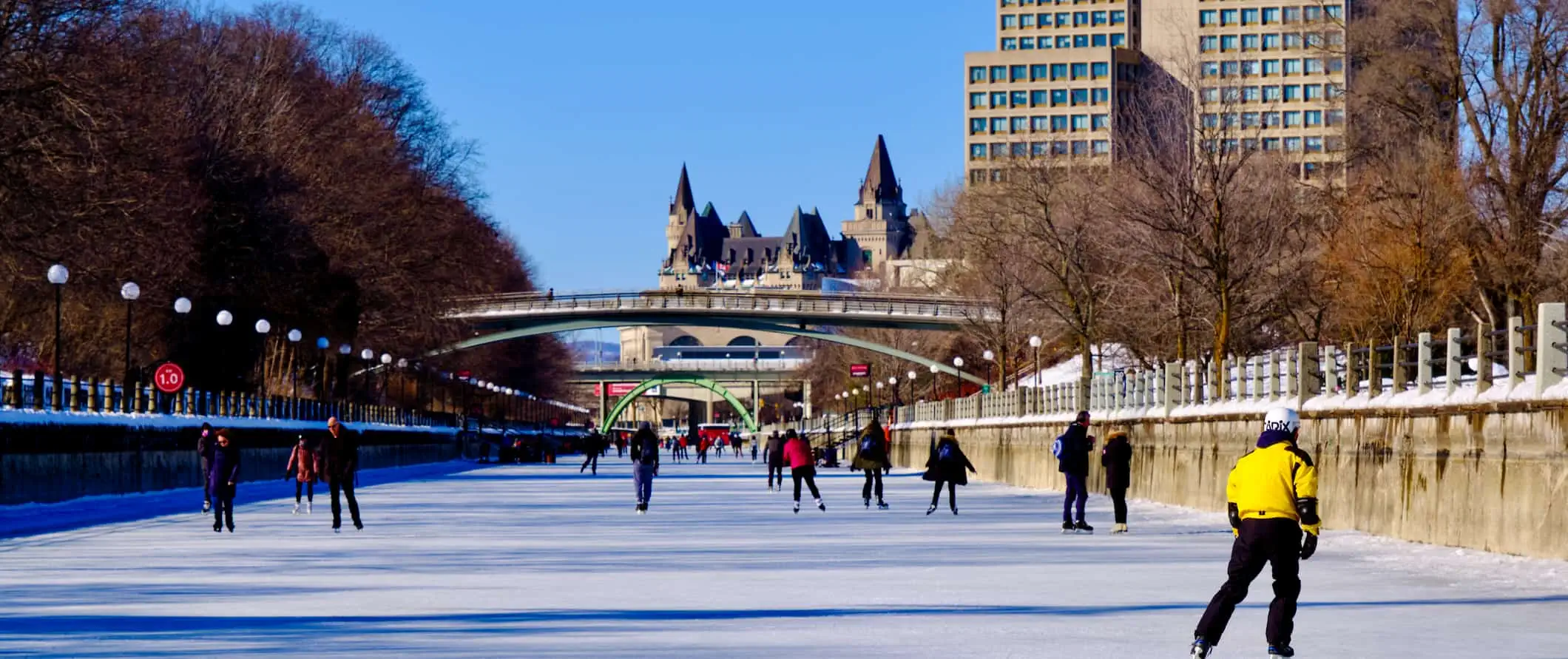 Persone che pattinano sul canale Rideau ghiacciato nella soleggiata Ottawa, Canada durante l'inverno