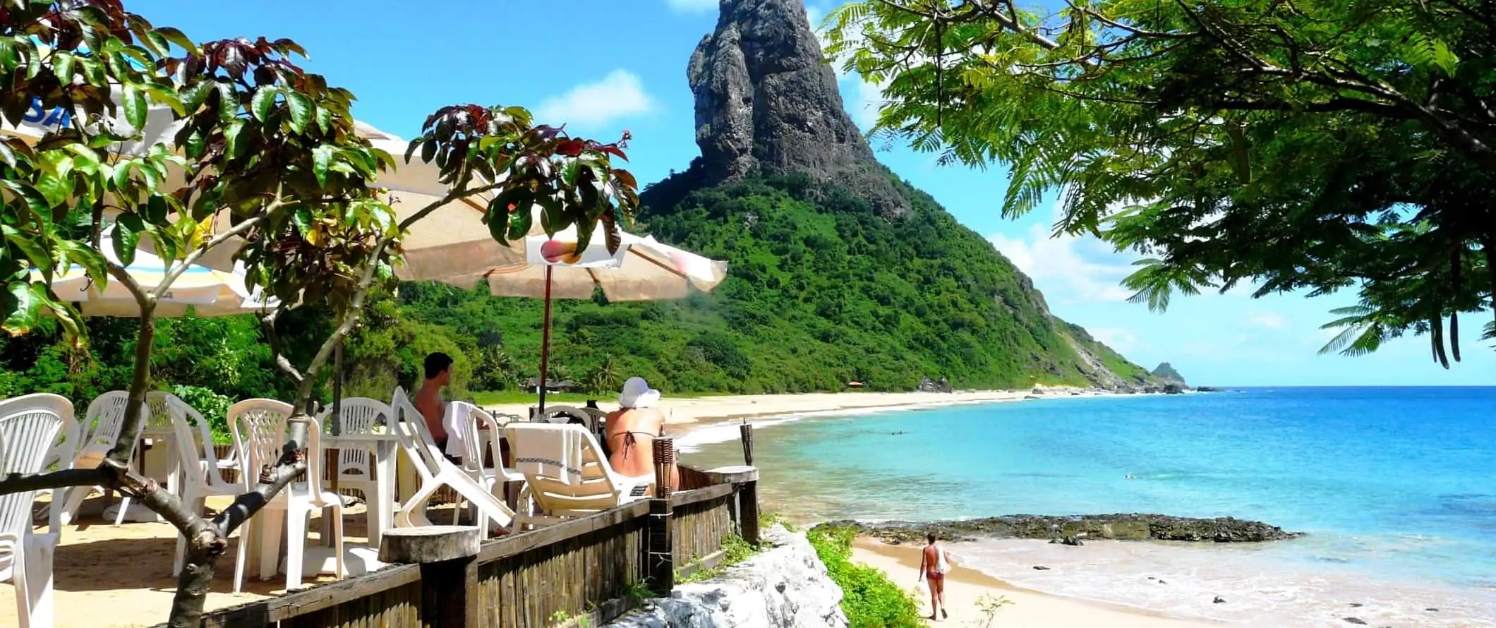 Žmonės sėdi paplūdimio kavinėje Fernando de Noronha mieste, Brazilijoje