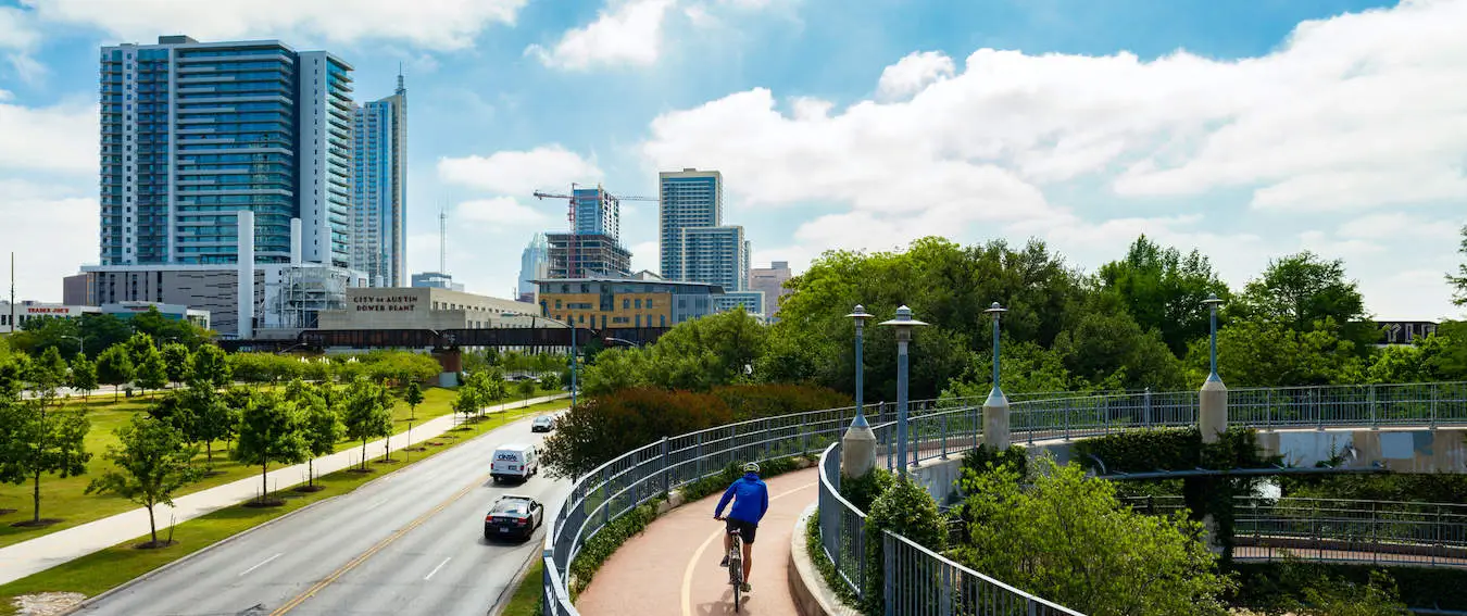 En mann som sykler på en smal gangvei i Austin, Texas