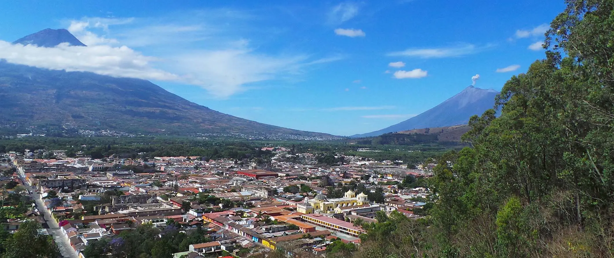 Une vue sur un volcan au Guatemala avec une petite ville nichée dans la vallée entre les montagnes