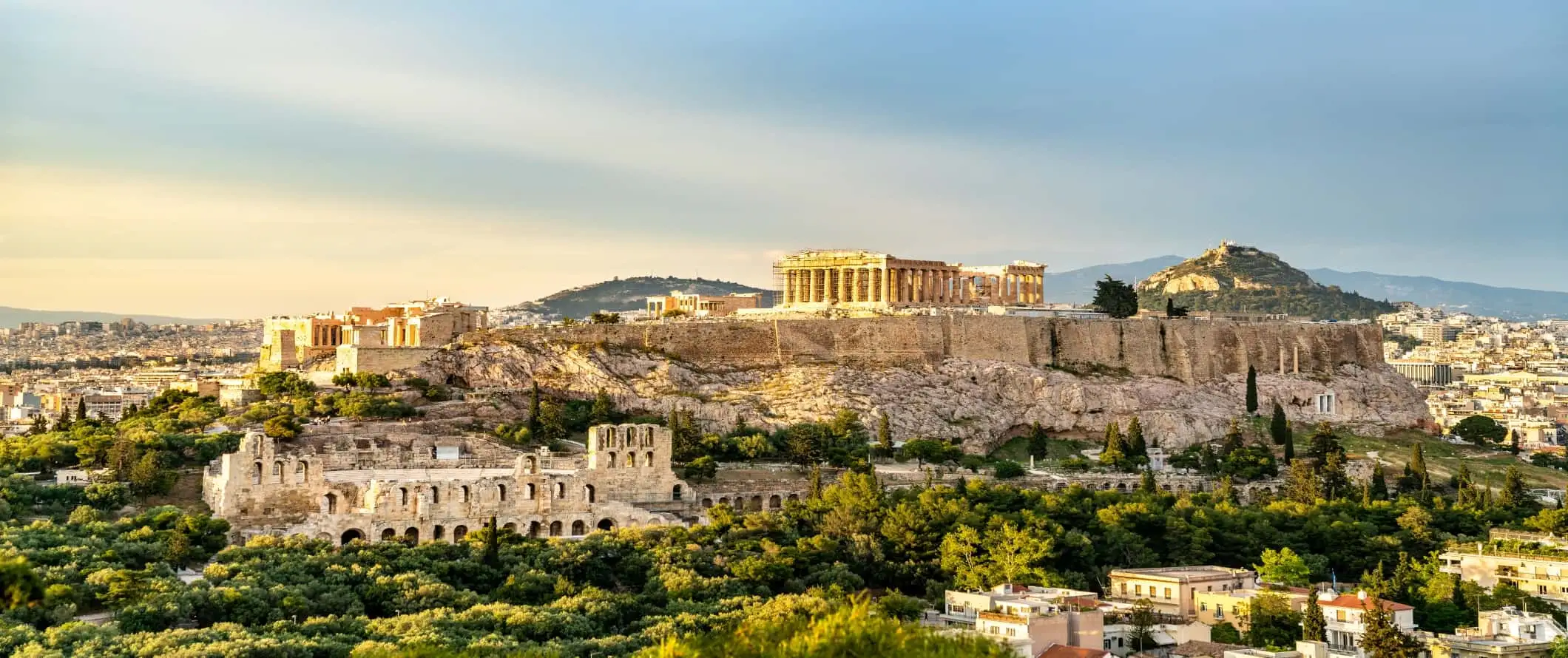 Pemandangan panorama Acropolis di atas bukit dengan runtuhan bersejarah lain di sekitar Athens, Greece