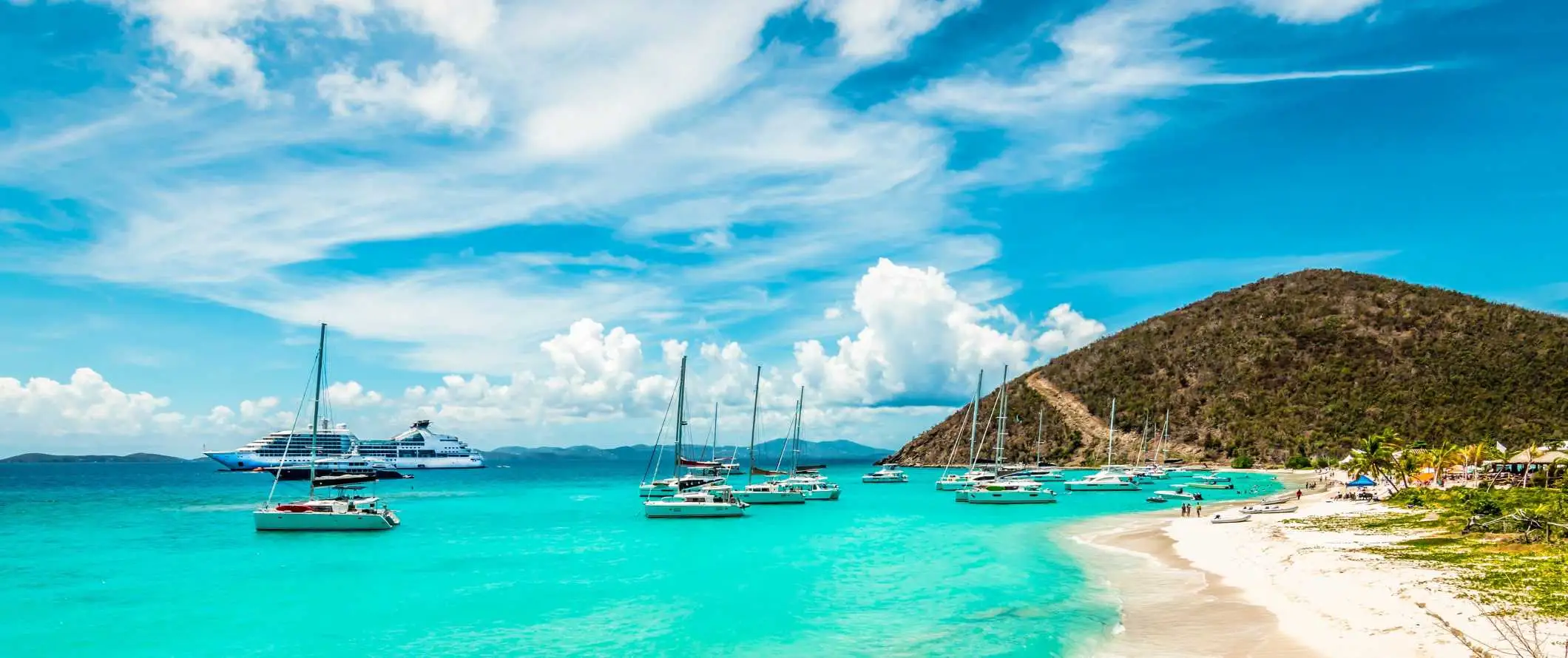 Barche a vela parcheggiate nelle acque azzurre dell'isola delle feste di Jost Van Dyke nelle Isole Vergini britanniche