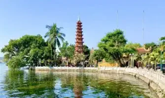 Een zonnige dag vlakbij het meer in Hanoi, met een hoge, historische pagode op de achtergrond