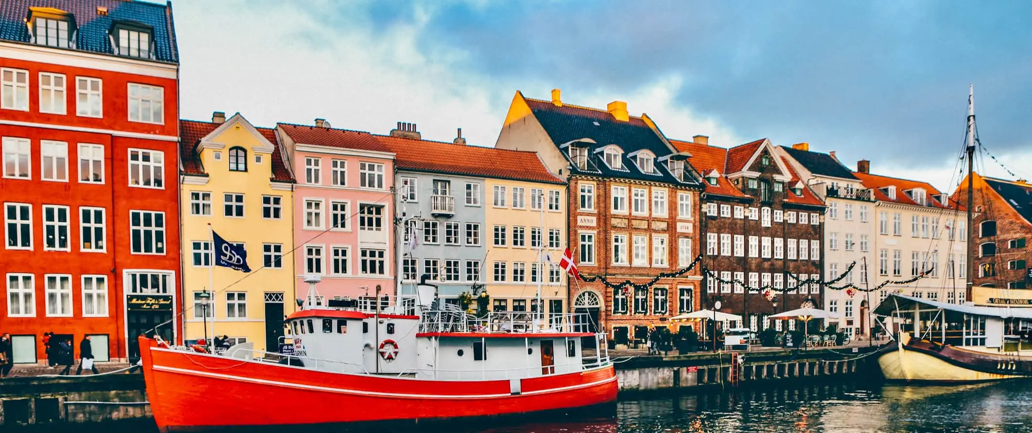 Edificios más coloridos a lo largo de un canal bordeado de barcos en Copenhague, Dinamarca