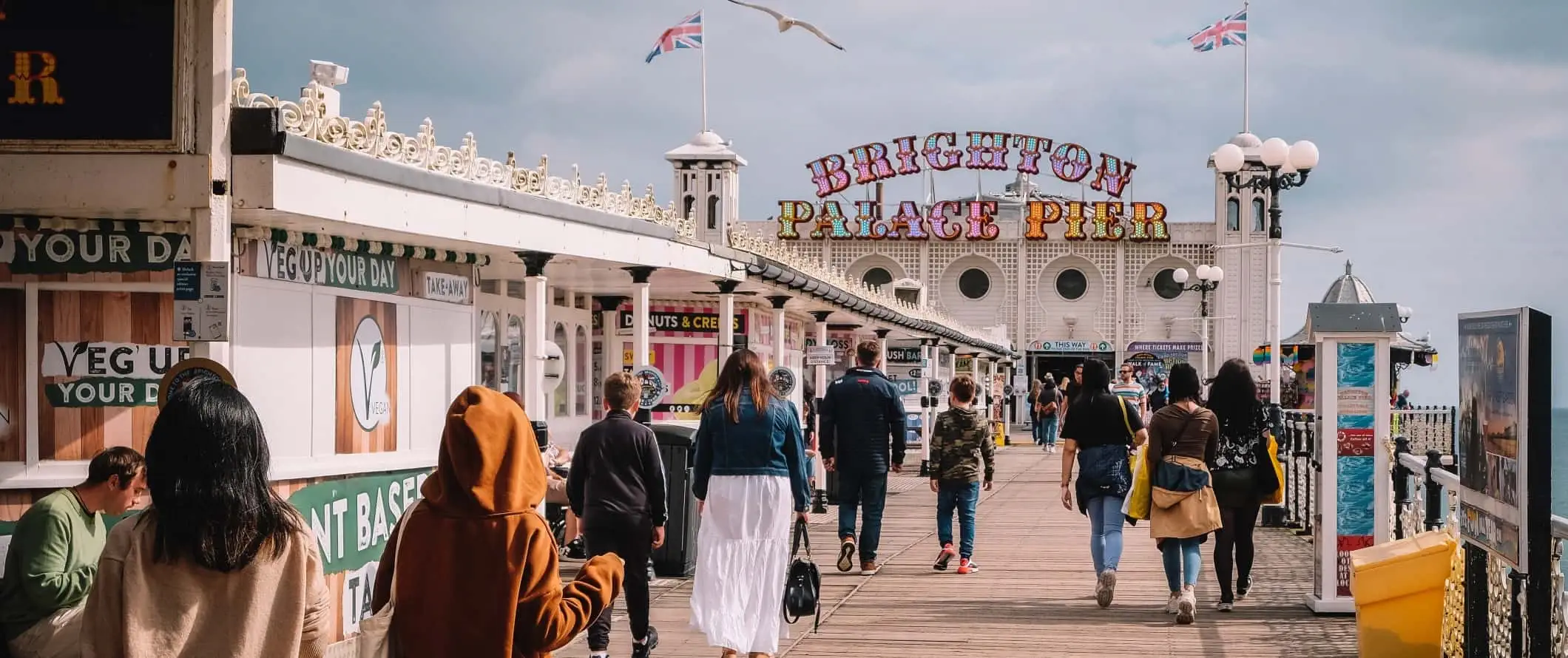 Folk går rundt på strandpromenaden på Brighton-molen i Brighton, Storbritannien