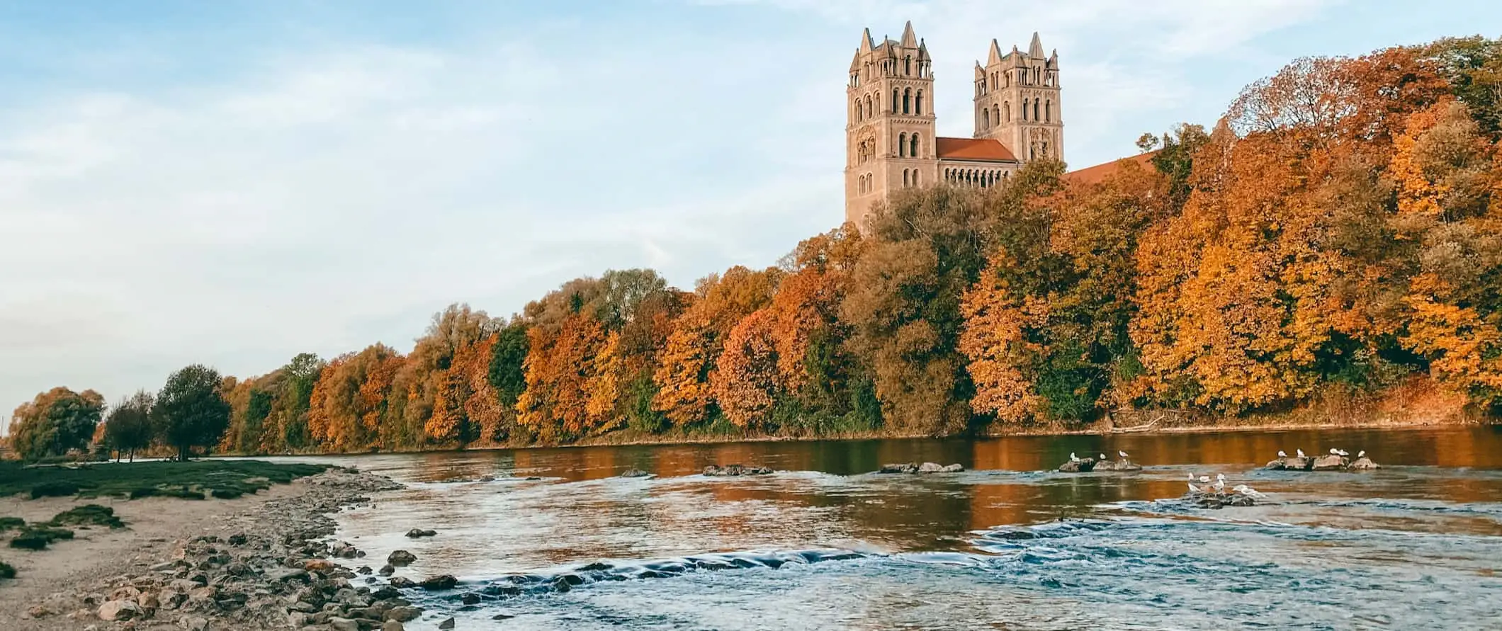 München, Duitsland gezien vanaf de rivier, omringd door bomen op een rustige dag