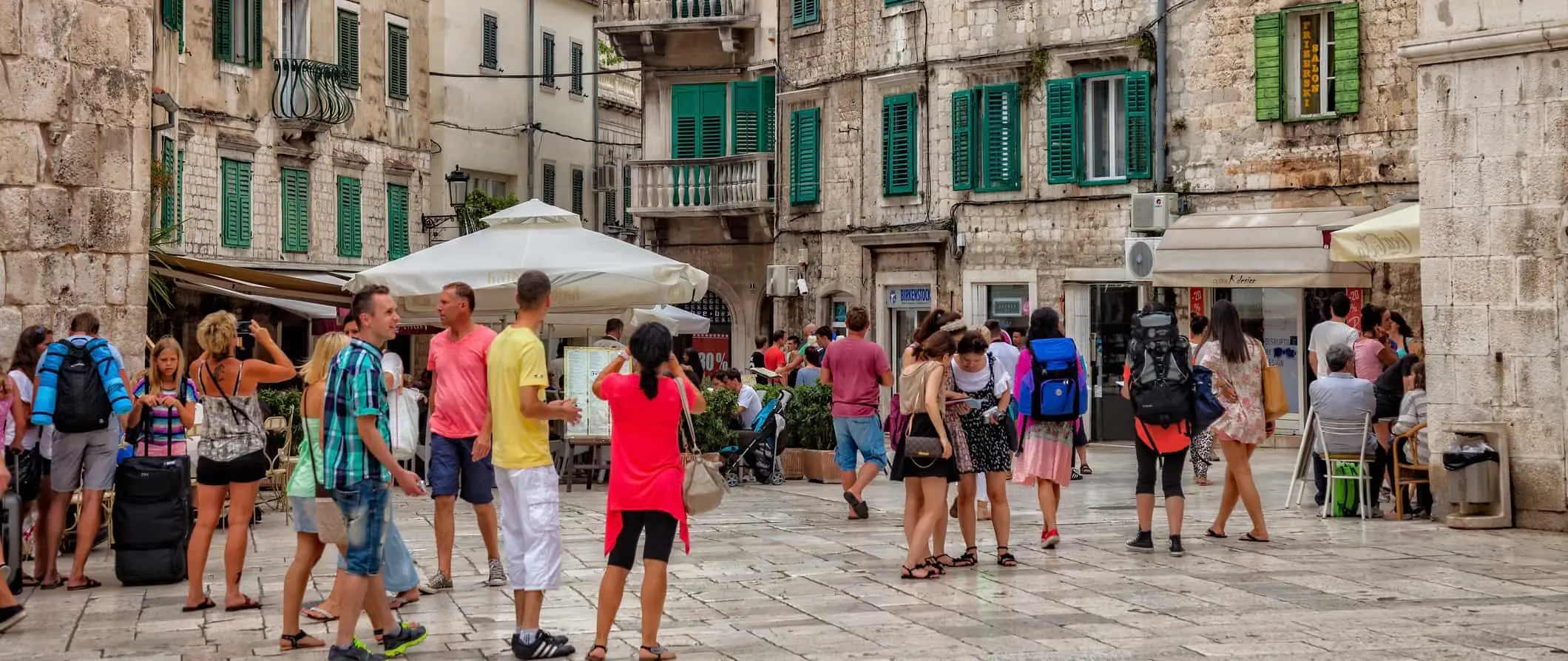 Orang ramai berjalan di jalan lama yang sempit di Split, Croatia