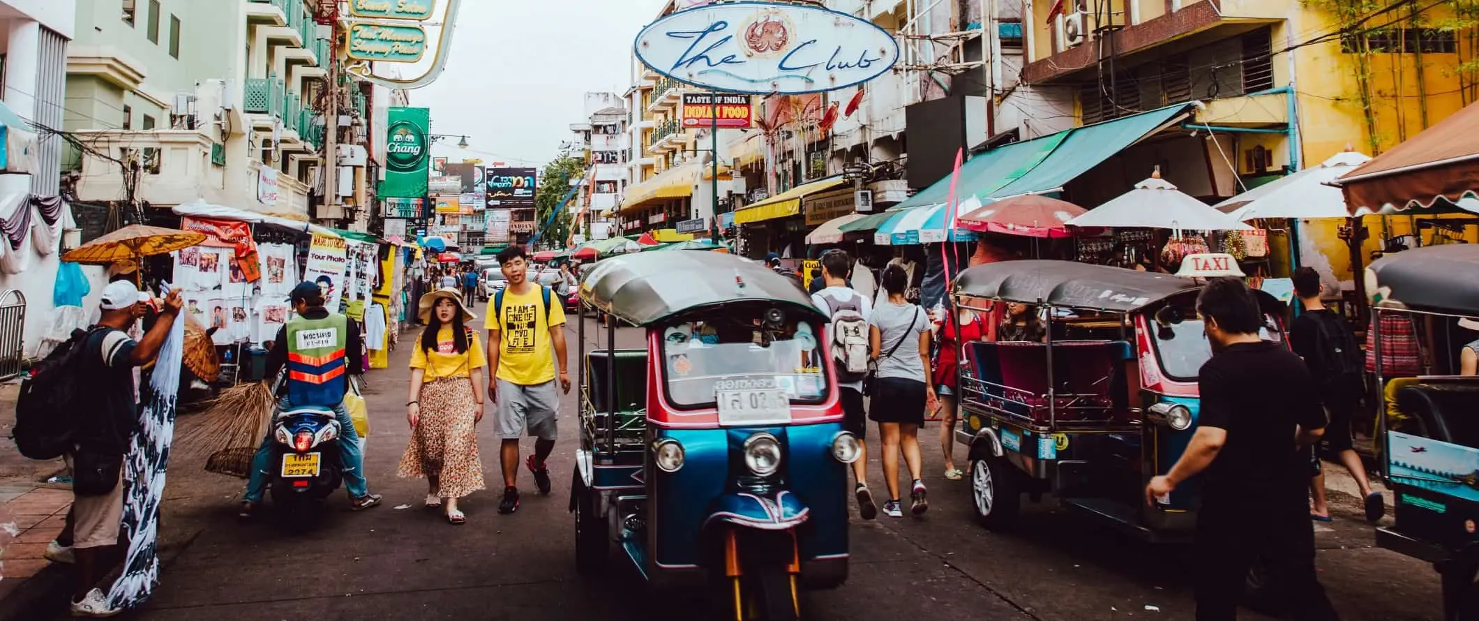 Stradă aglomerată din Bangkok, Thailanda, plină de oameni și ricșe