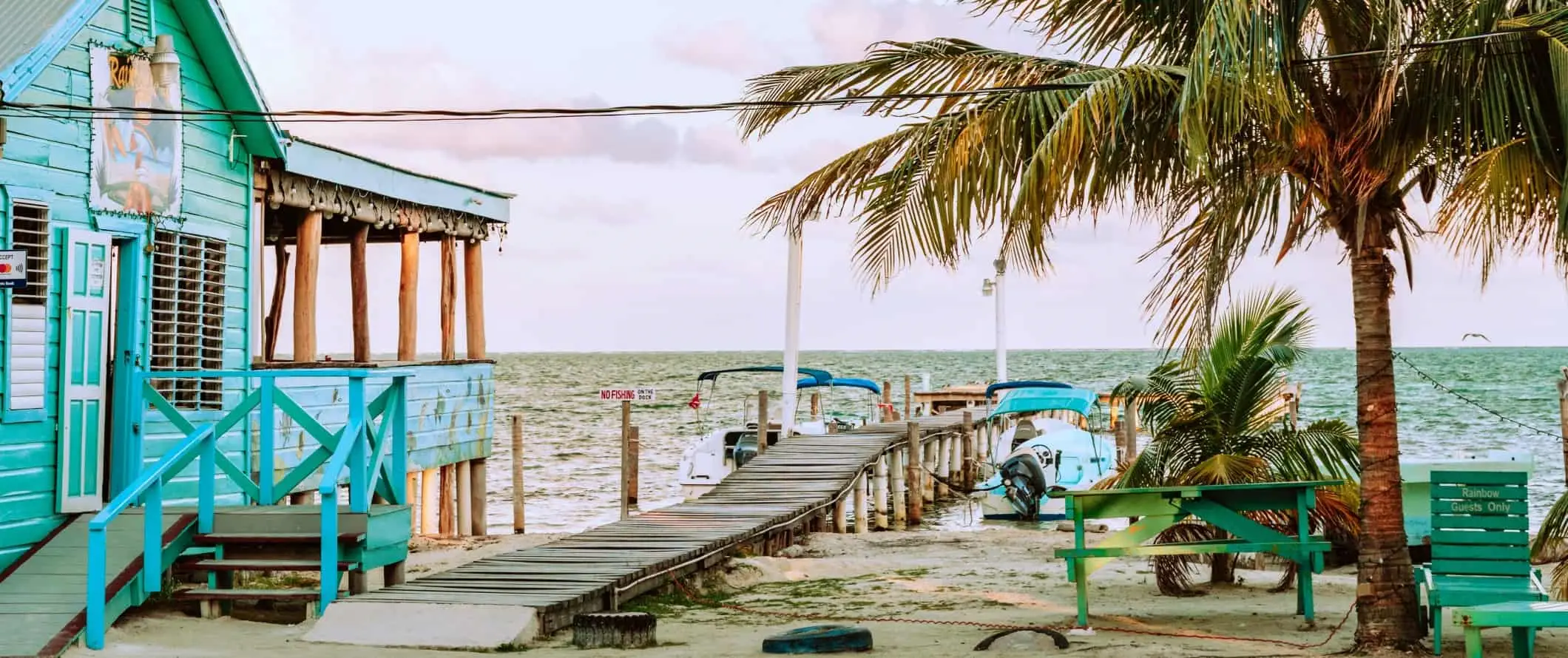 Turkoosivärinen talo rannan varrella laiturilla Caye Caulkerin saarella Belizessä