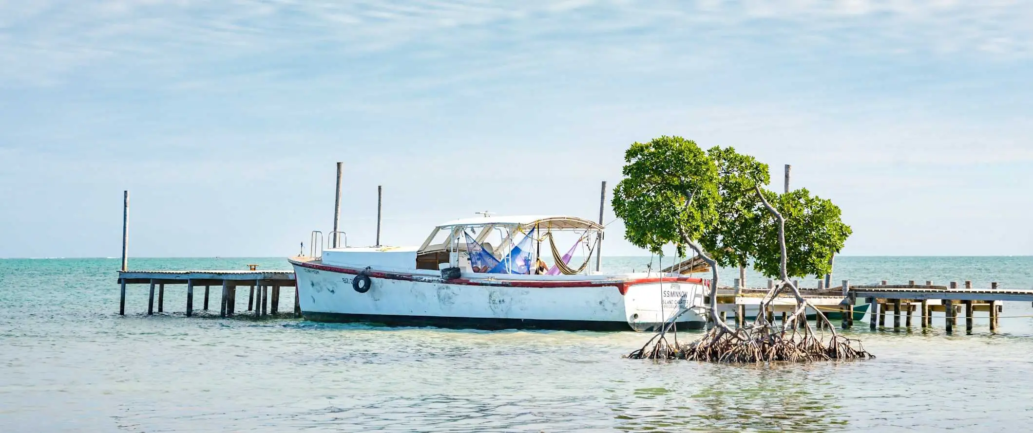 En båd ved en kaj i vandet i Caye Caulker, Belize