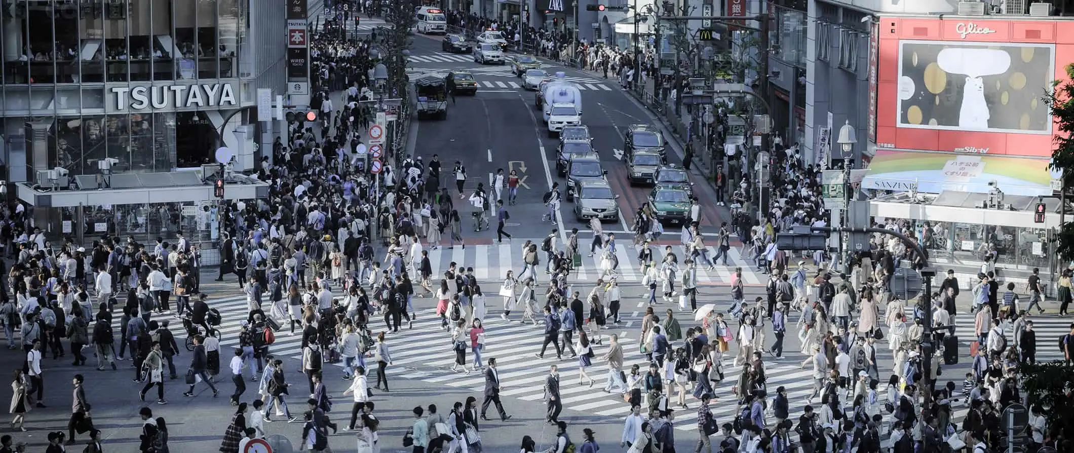 Eine belebte Kreuzung in Tokio, Japan, an der Tausende von Menschen die Straße überqueren