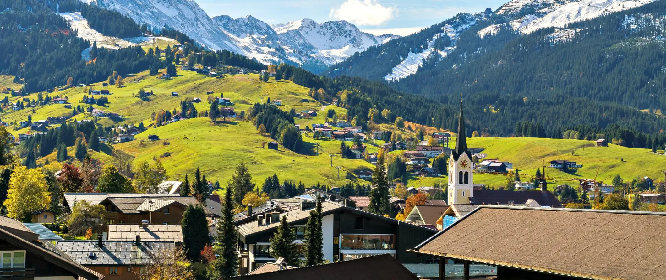 isang tradisyonal na tahanan ng Austrian kung saan matatanaw ang mga bundok na natatakpan ng niyebe at mga gumugulong na burol sa kanayunan ng Austria