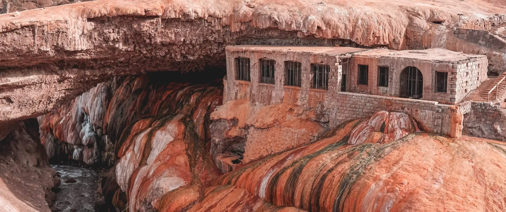 Historisch bakstenen gebouw ingebouwd in koper-gouden minerale afzettingen in Puente del Inca nabij Mendoza, Argentinië