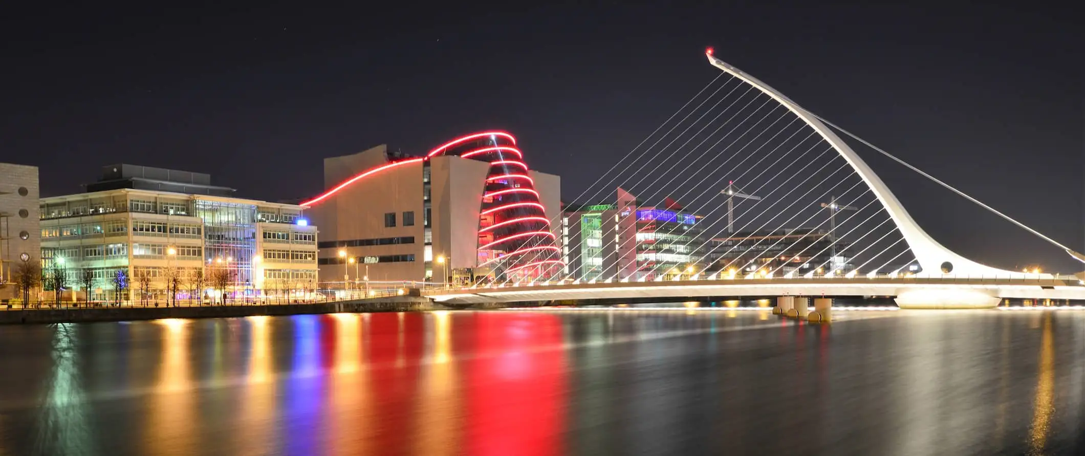 De stad Dublin, Ierland, verlicht door het water tijdens een donkere nacht