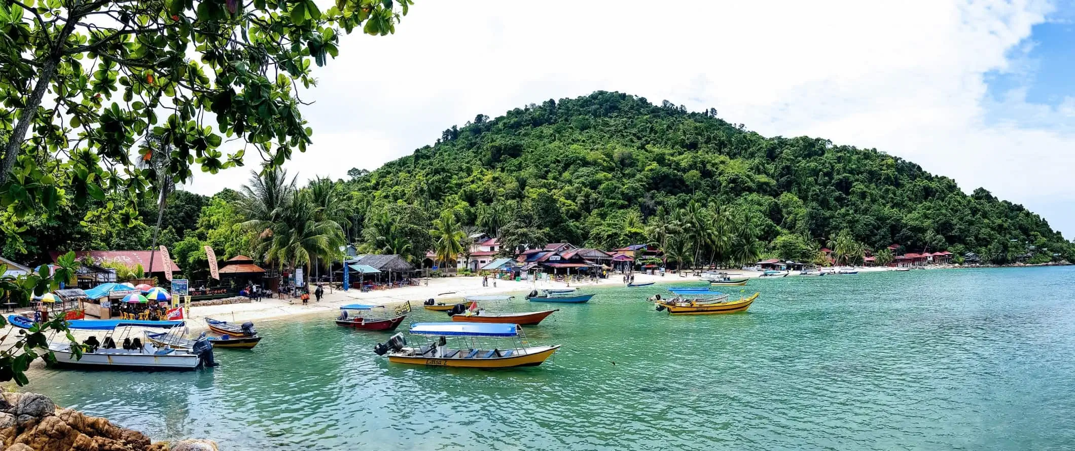 Boote vor Anker im Wasser vor einem Strand auf den Perhentian-Inseln, Malaysia