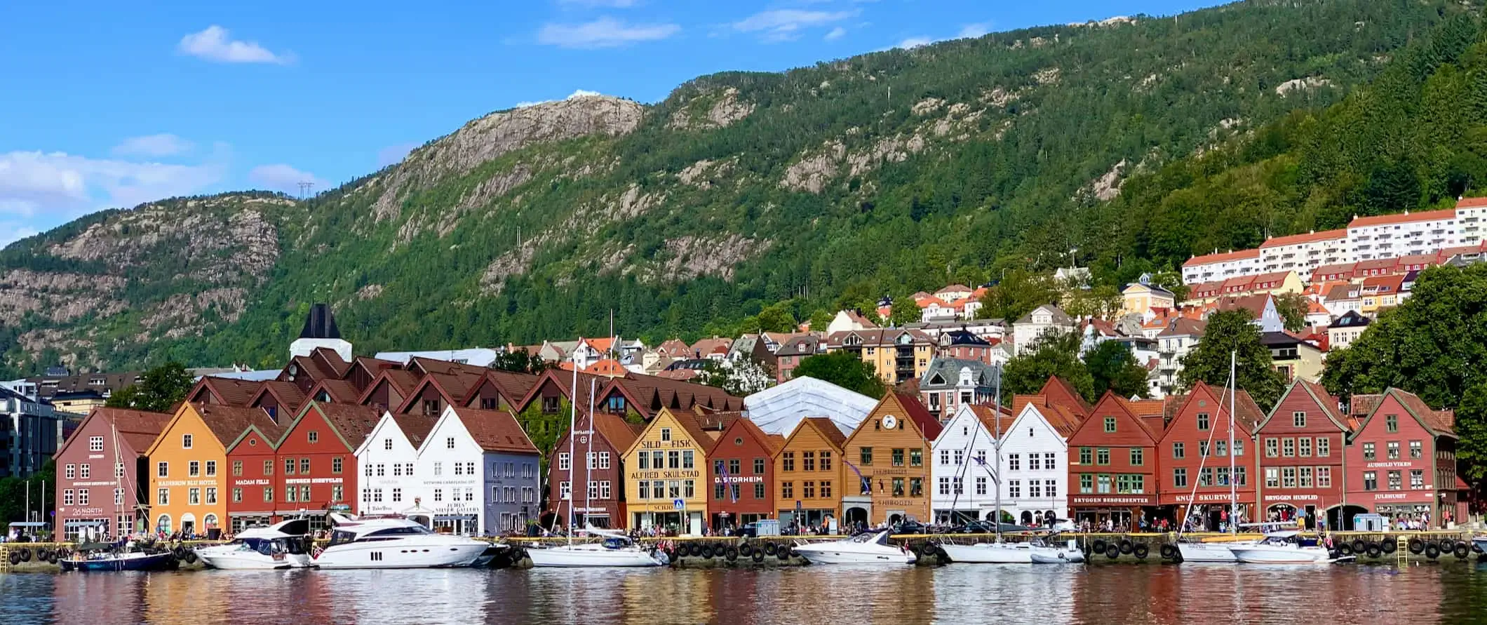 Uma fileira de edifícios antigos coloridos ao longo das margens calmas de Bergen, Noruega