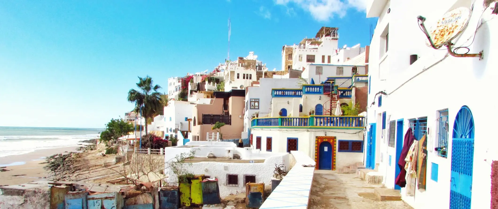 Una vista al mar a lo largo de un pequeño pueblo cerca de la playa en el soleado Marruecos