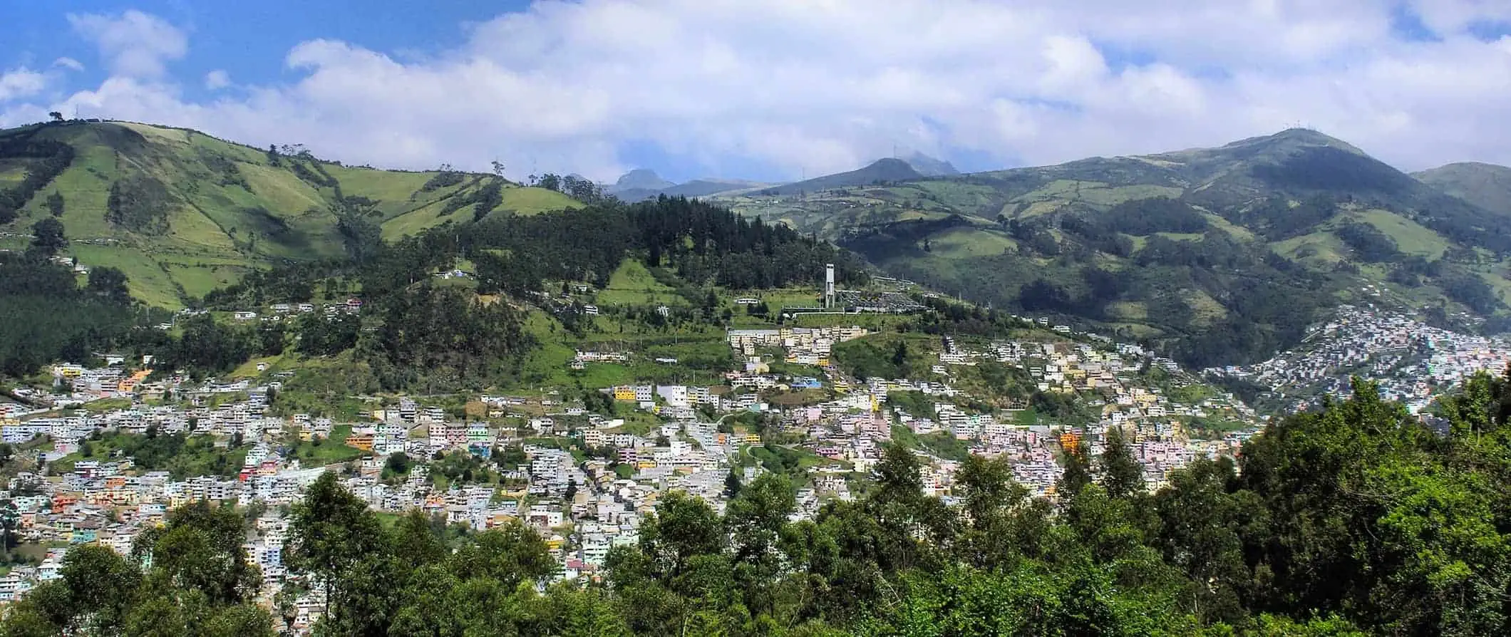 widok z lotu ptaka na Quito w Ekwadorze otoczone zielonymi wzgórzami w słoneczny letni dzień