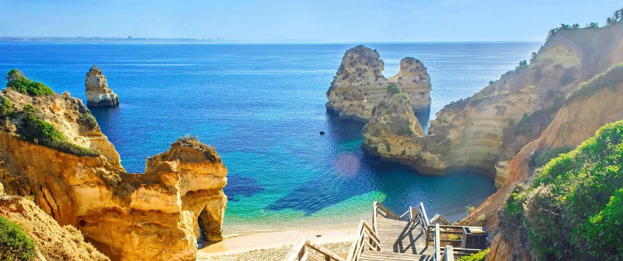 Escadas de madeira que descem para uma linda praia ao longo da costa de Portugal, perto de Lagos