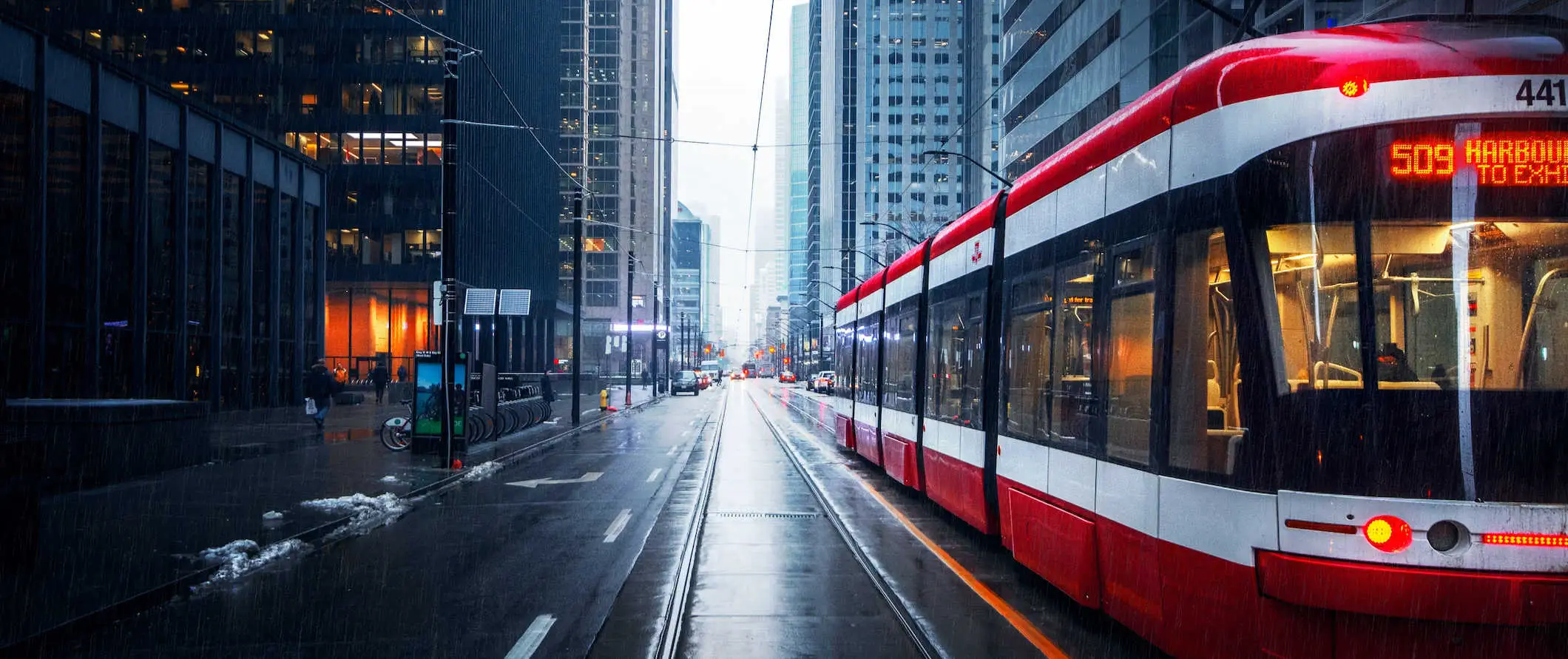 Um bonde TTC circulando pelo centro de Toronto, Canadá, em um dia chuvoso