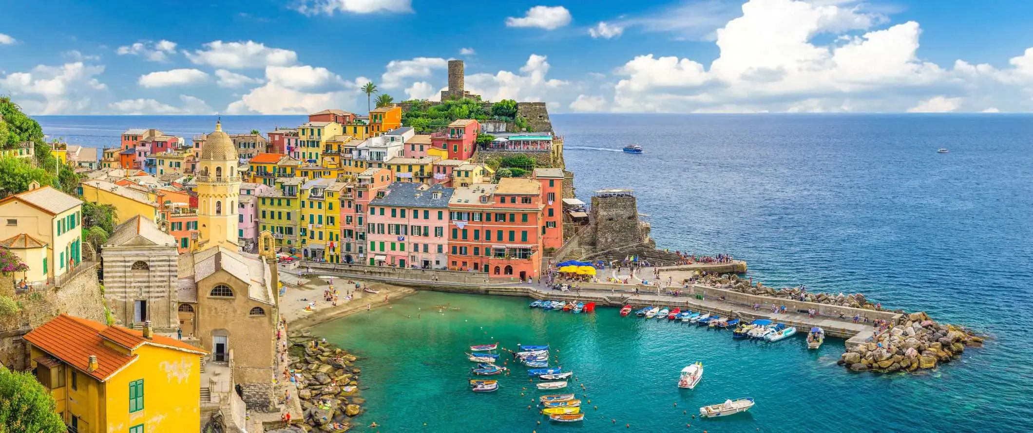 Spalvingi pastatai ir uostas, užpildytas valtimis Vernazza miestelyje Cinque Terre, Italijoje.