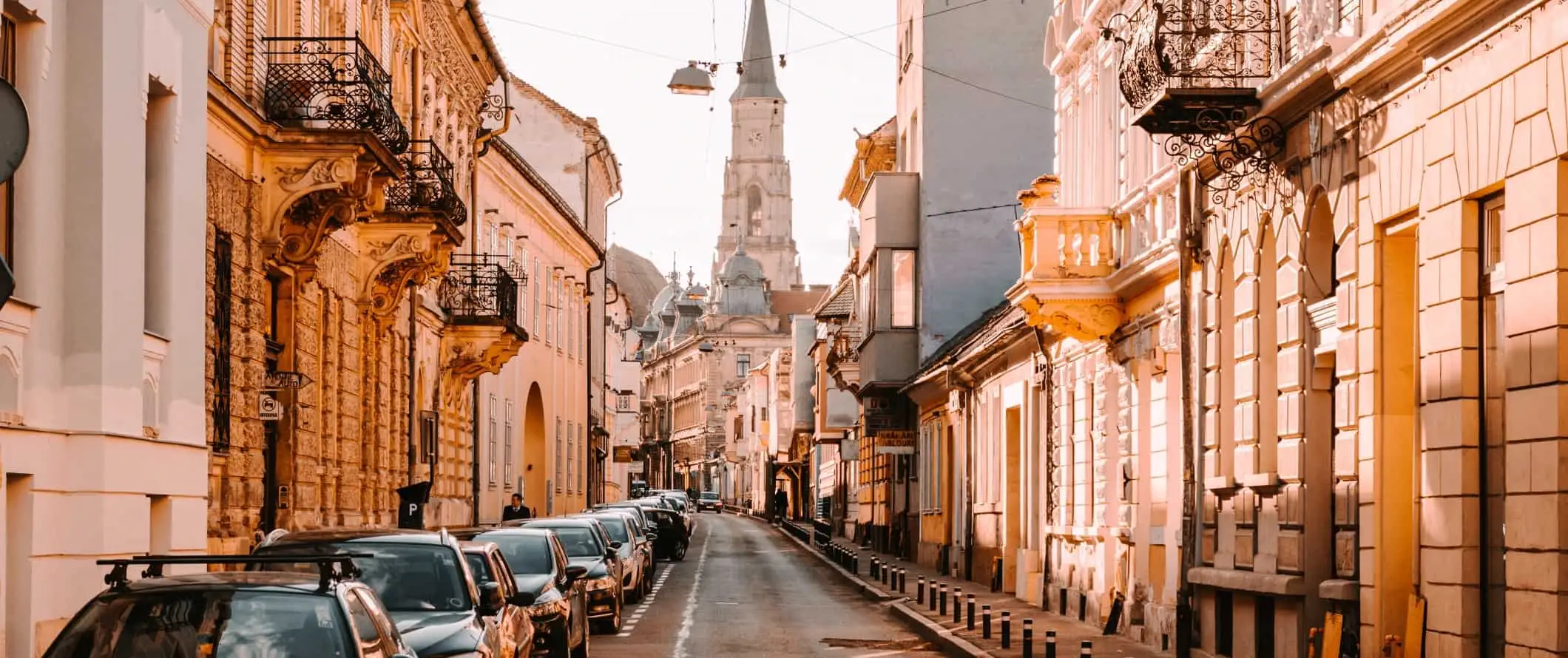 Calles históricas a última hora de la tarde con una iglesia al fondo en la ciudad de Cluj-Napoca, Rumania