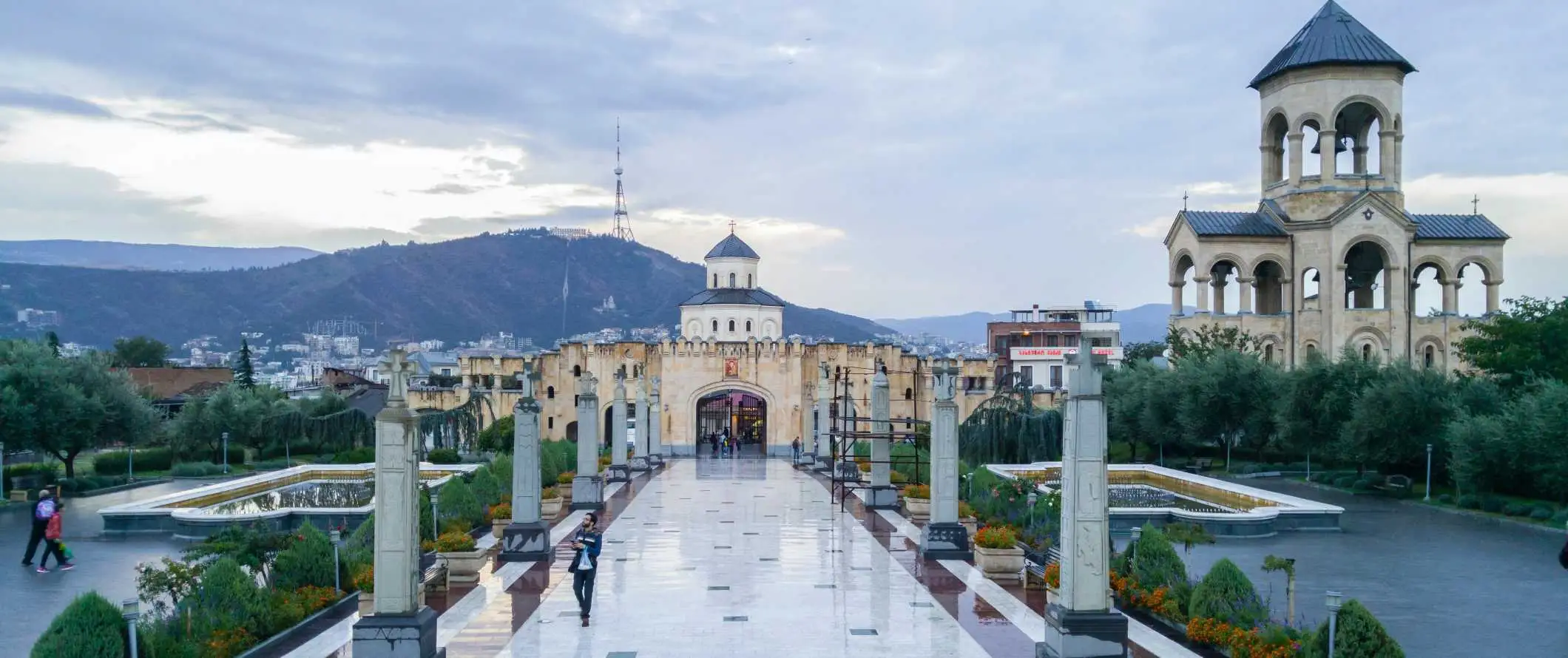 Menschen, die einen Weg vor der Kathedrale der Heiligen Dreifaltigkeit in Tiflis, Georgien, entlanggehen