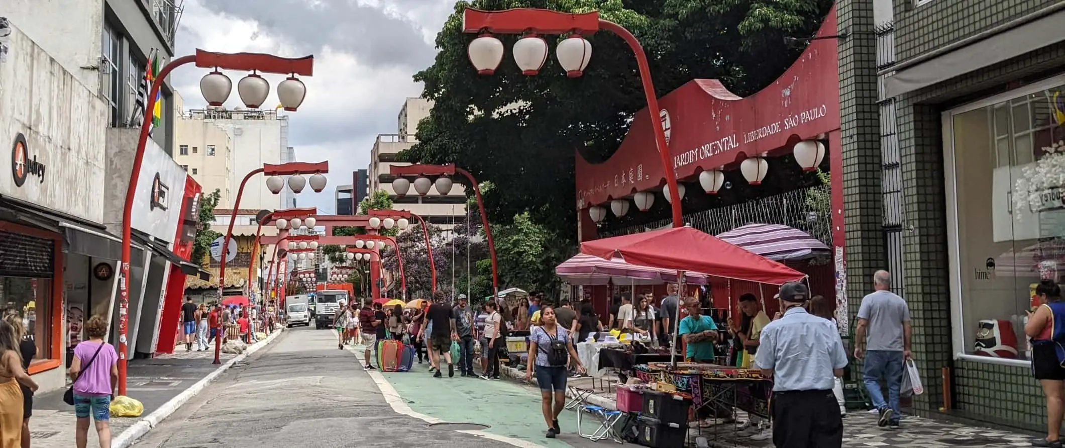 Pejzaż uliczny z ludźmi chodzącymi pod kolorowymi czerwonymi lampami w Liberdade, Japantown w São Paulo, Brazylia