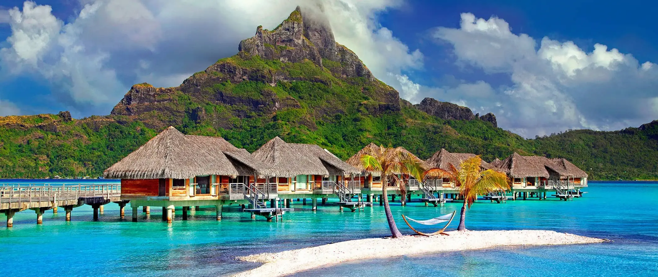 Overvannsbungalower og klart vann ved en pittoresk strand i vakre Fransk Polynesia