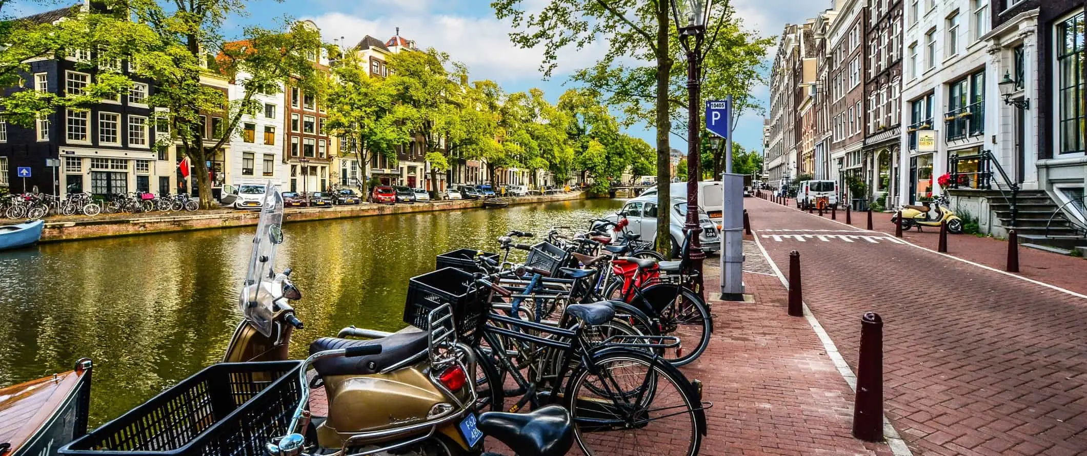 Conjunto de bicicletas trancadas ao longo de um canal em Amsterdã, na Holanda.