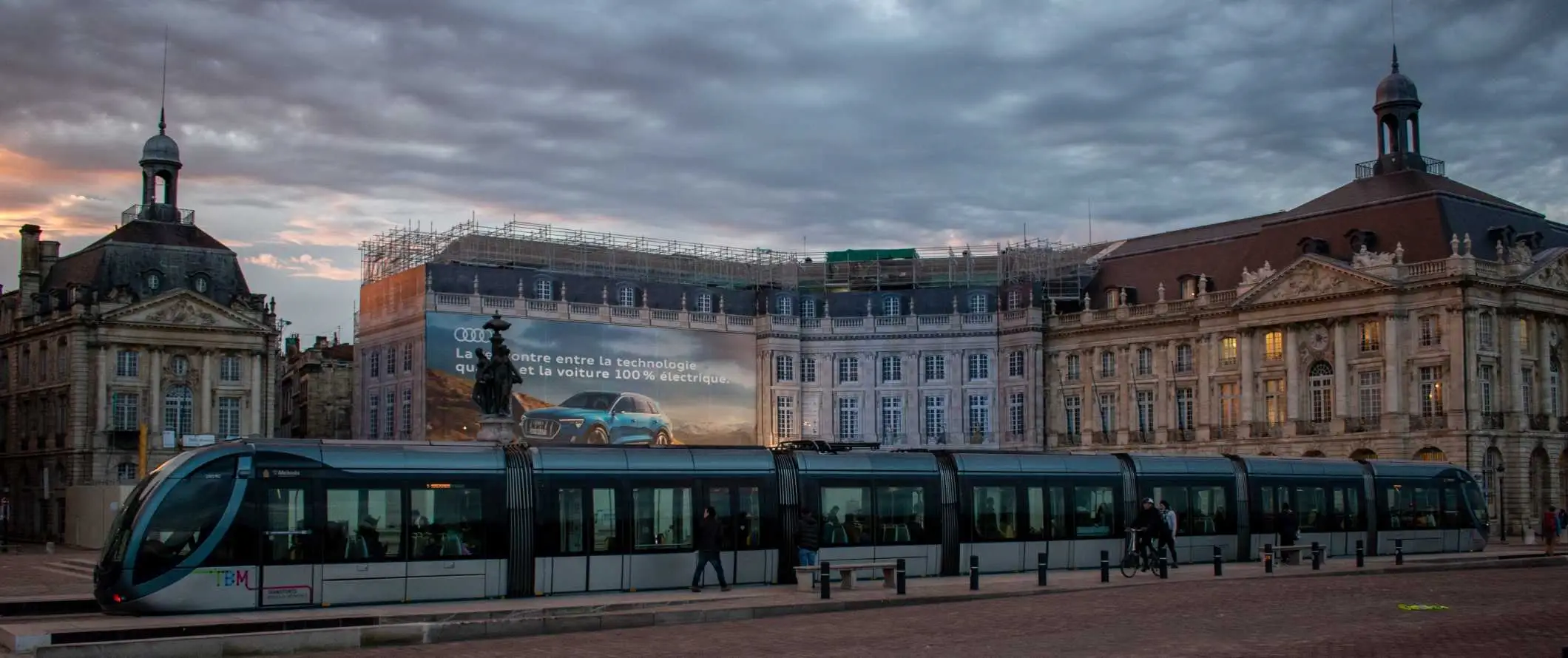 Cilvēki, kas saulrietā iekāpj tramvajā, Bordo vecpilsētā, Francijā