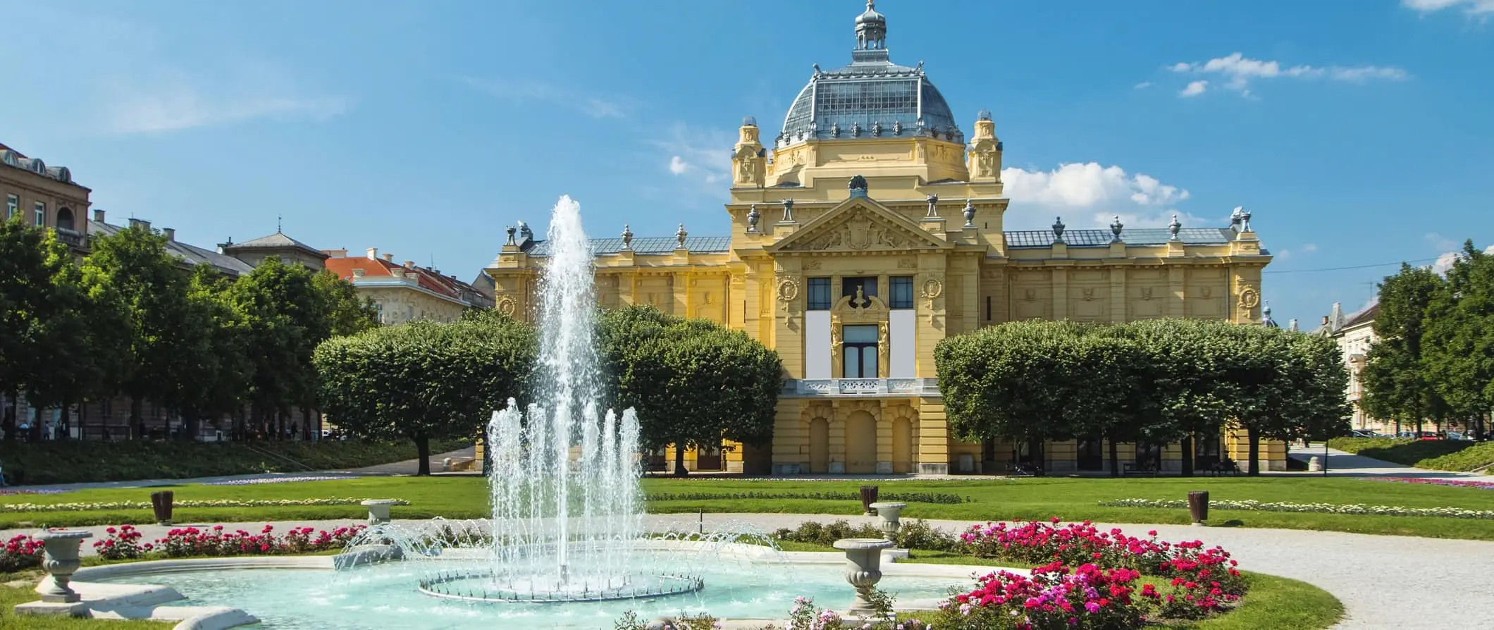 Een groot historisch gebouw met een waterfontein in Zagreb, Kroatië