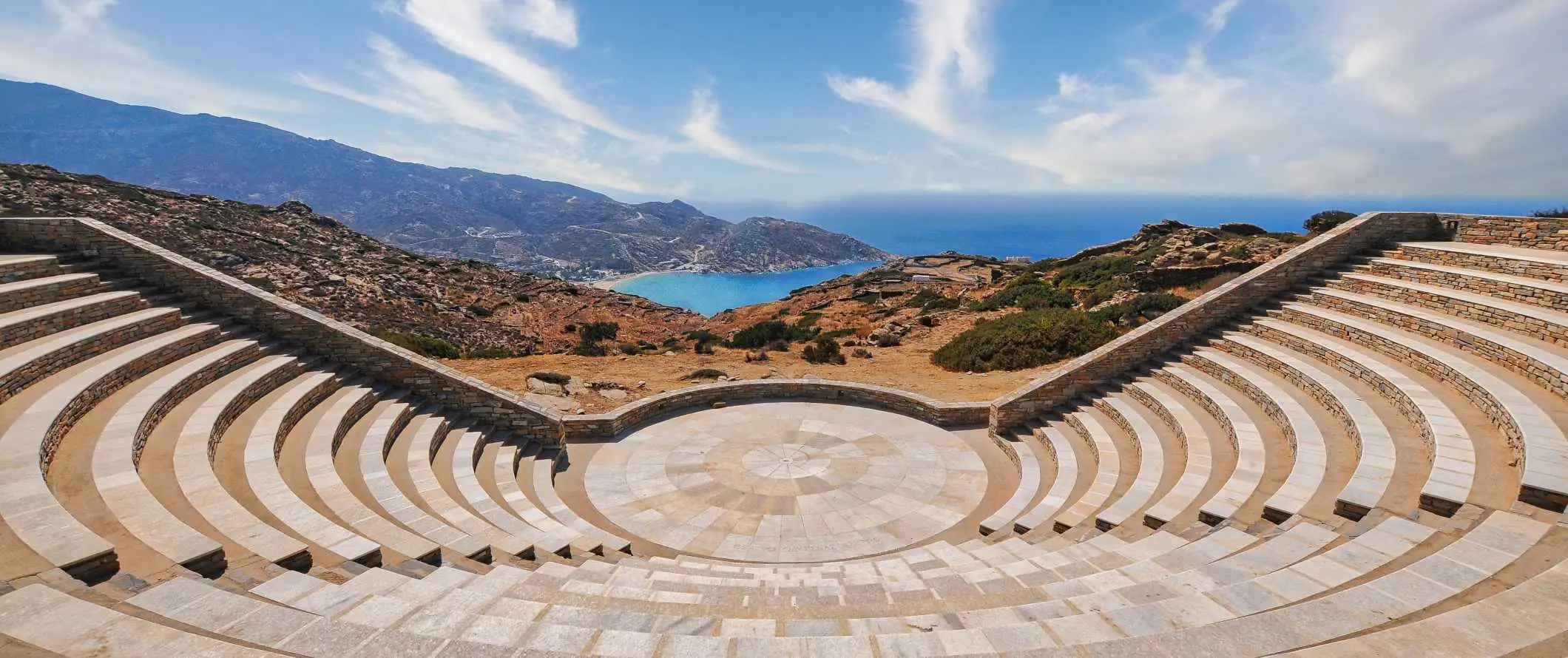 Pemandangan panorama amfiteater terbuka moden yang menghadap ke puncak bukit dan Laut Mediterranean di Ios, Greece